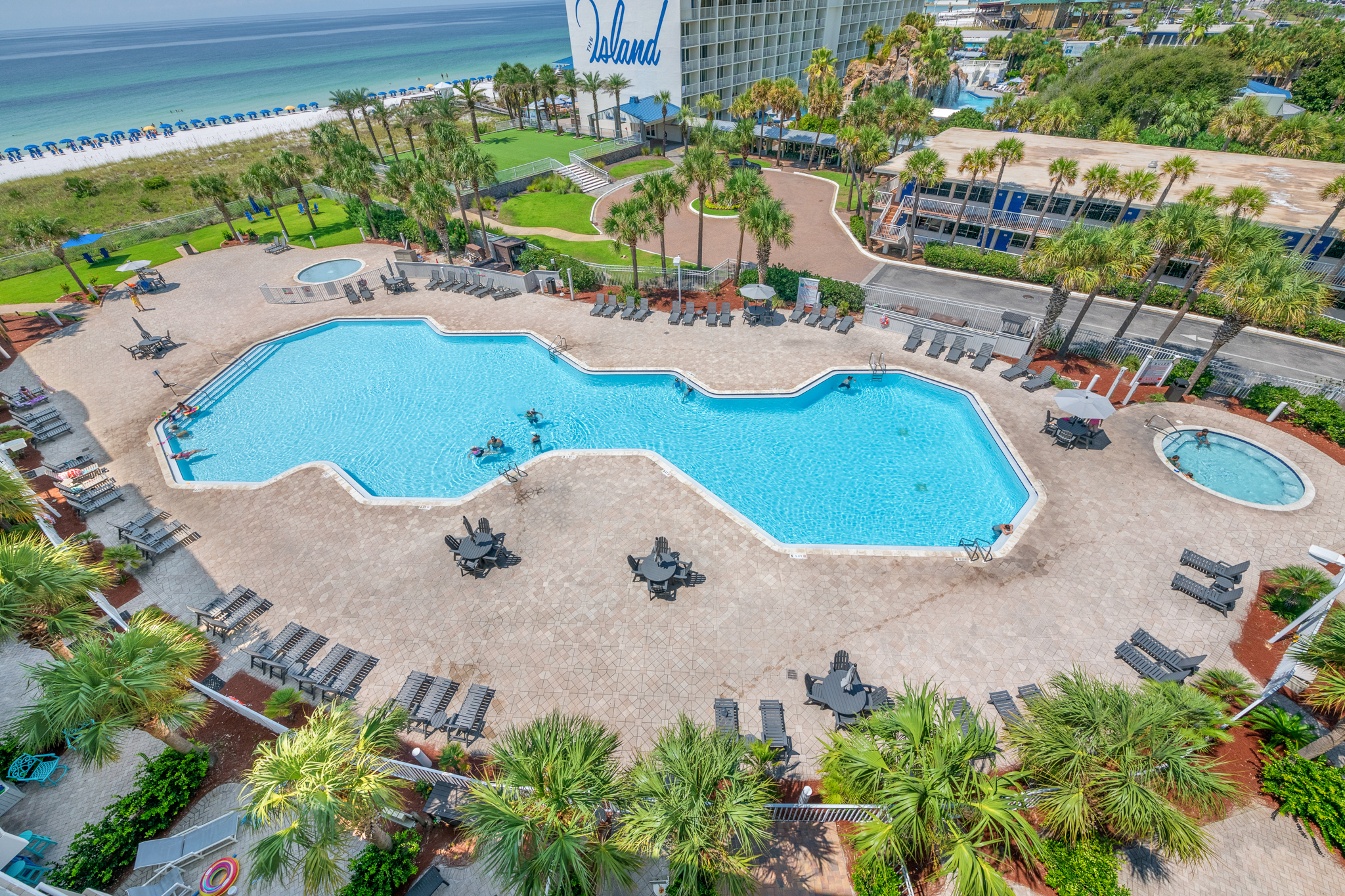 Elevated balcony view overlooking the resort pools and palm trees.