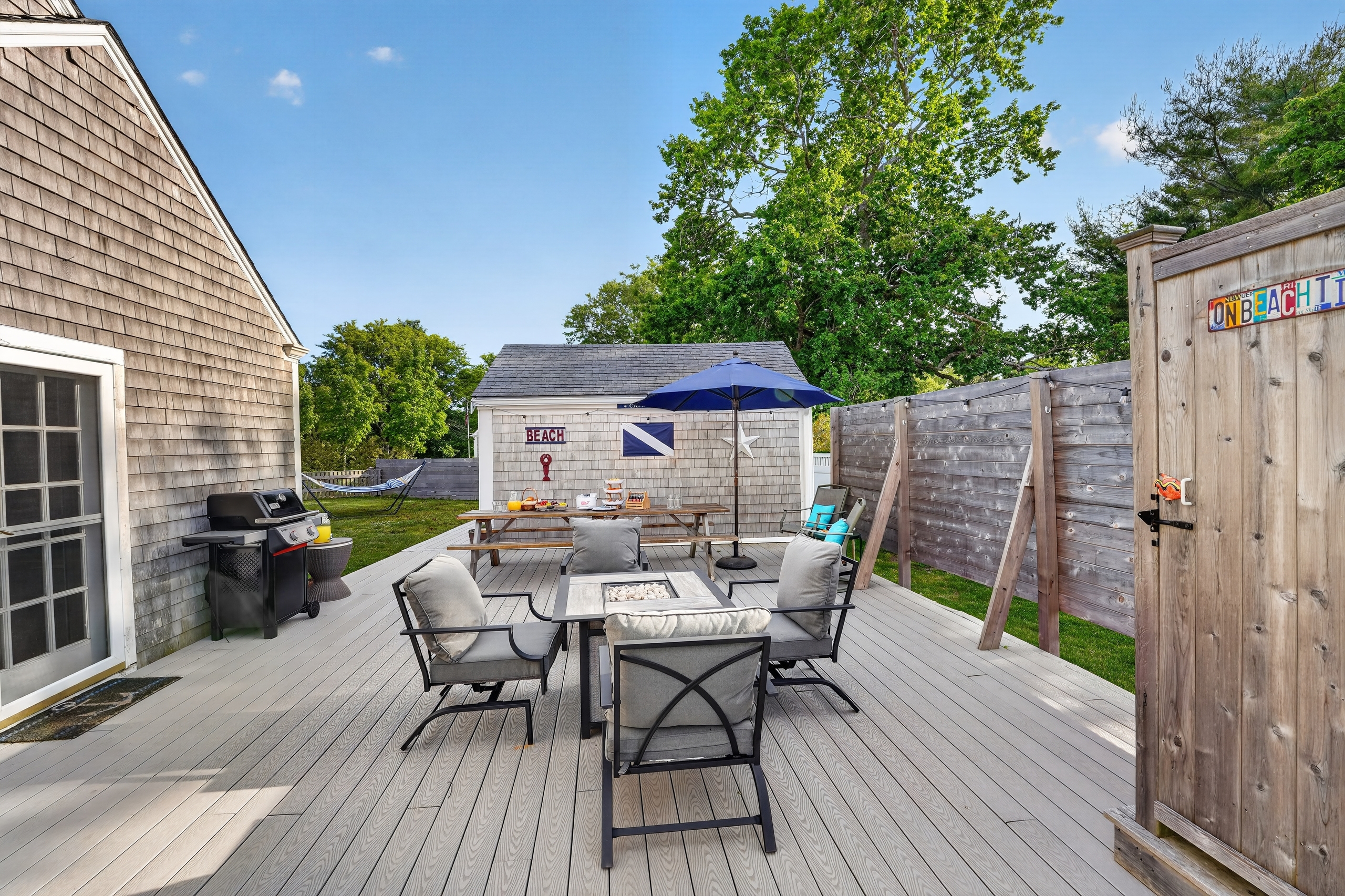 Private outdoor deck with dining table, grill, and fenced backyard—perfect for outdoor meals and evening gatherings.