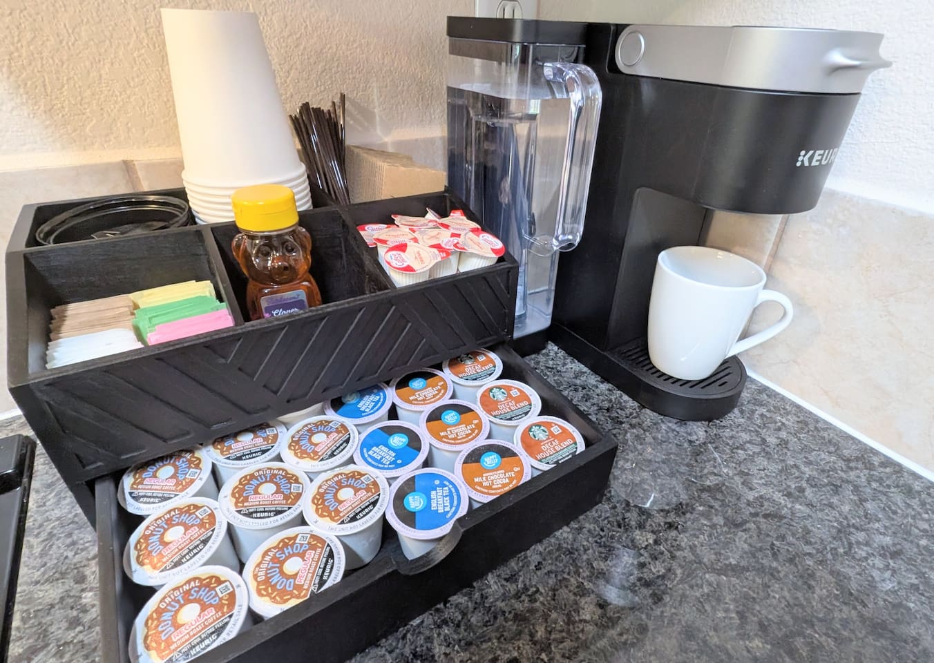 Fully stocked coffee bar includes: coffee, hot chocolate, decaf, tea k-cups • variety of sugar and sweeteners • local honey • creamer cups • k-cup maker with multiple brewing options • to-go cups with lids