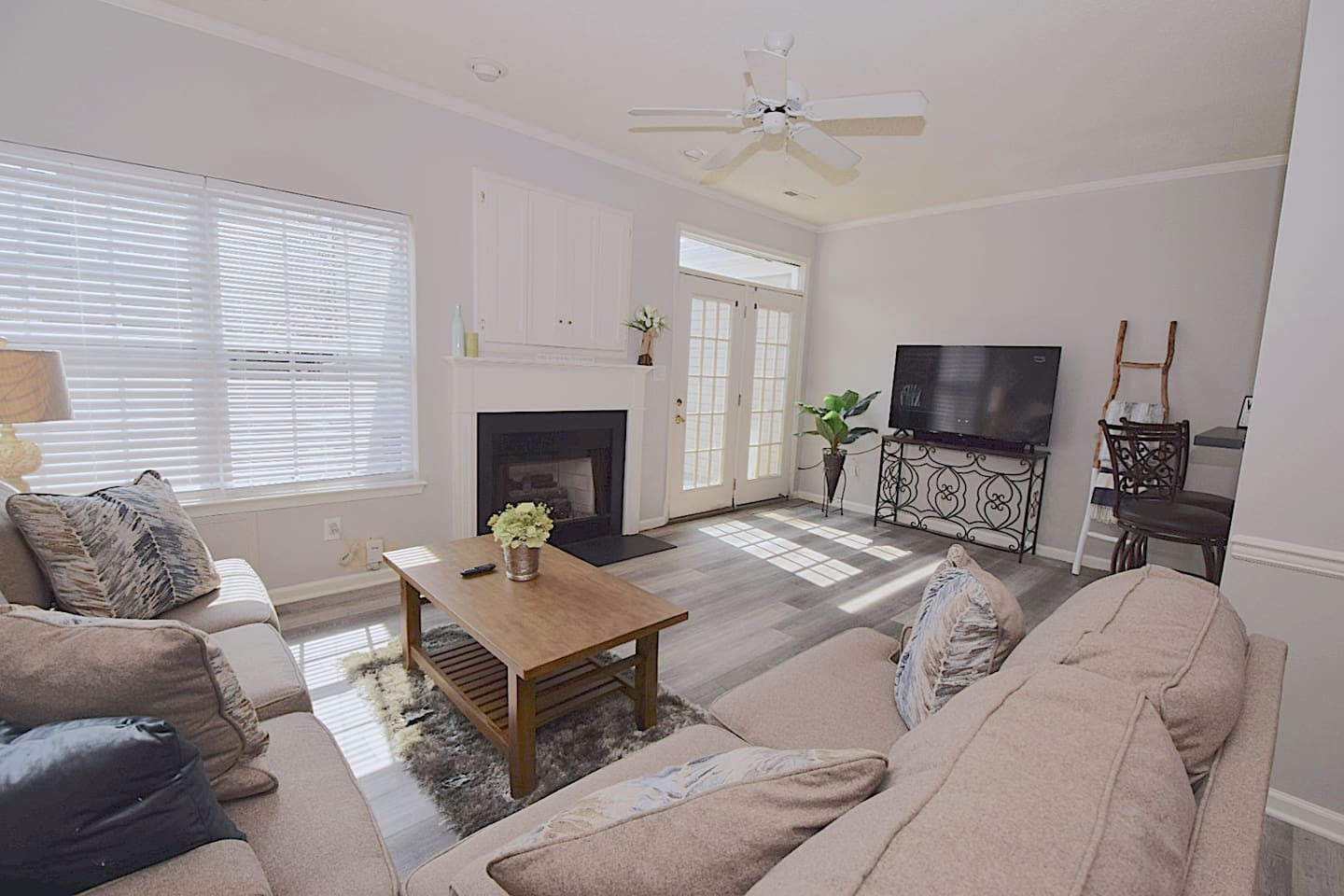 Nice open living room equipped with a 55in 4K TV, couches and bar stools.