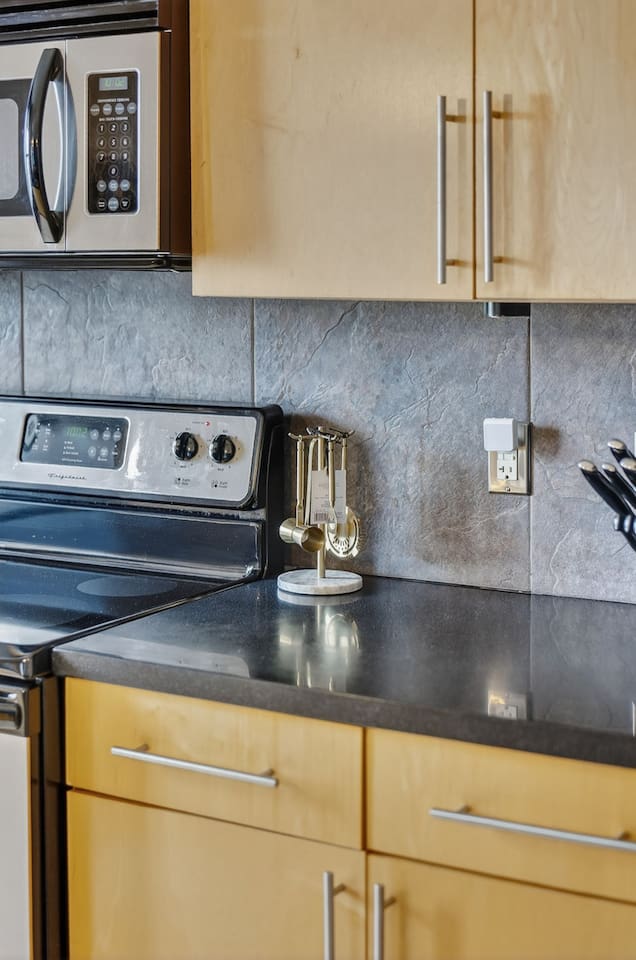 Fully equipped kitchen with stainless steel stove, microwave, and cooking essentials. Enjoy convenient meal prep with modern finishes, ample counter space, and everything you need for a comfortable stay.