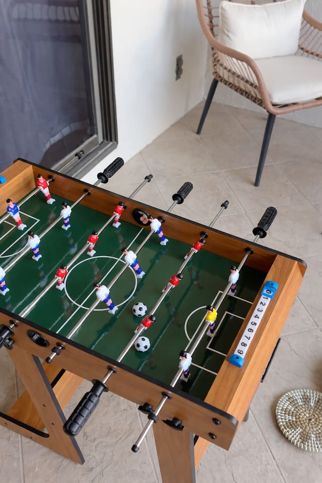 Spacious private balcony with direct access from the kitchen and Bedroom 4, complete with cozy string lights and a mini foosball table — perfect for evening gatherings or casual games.