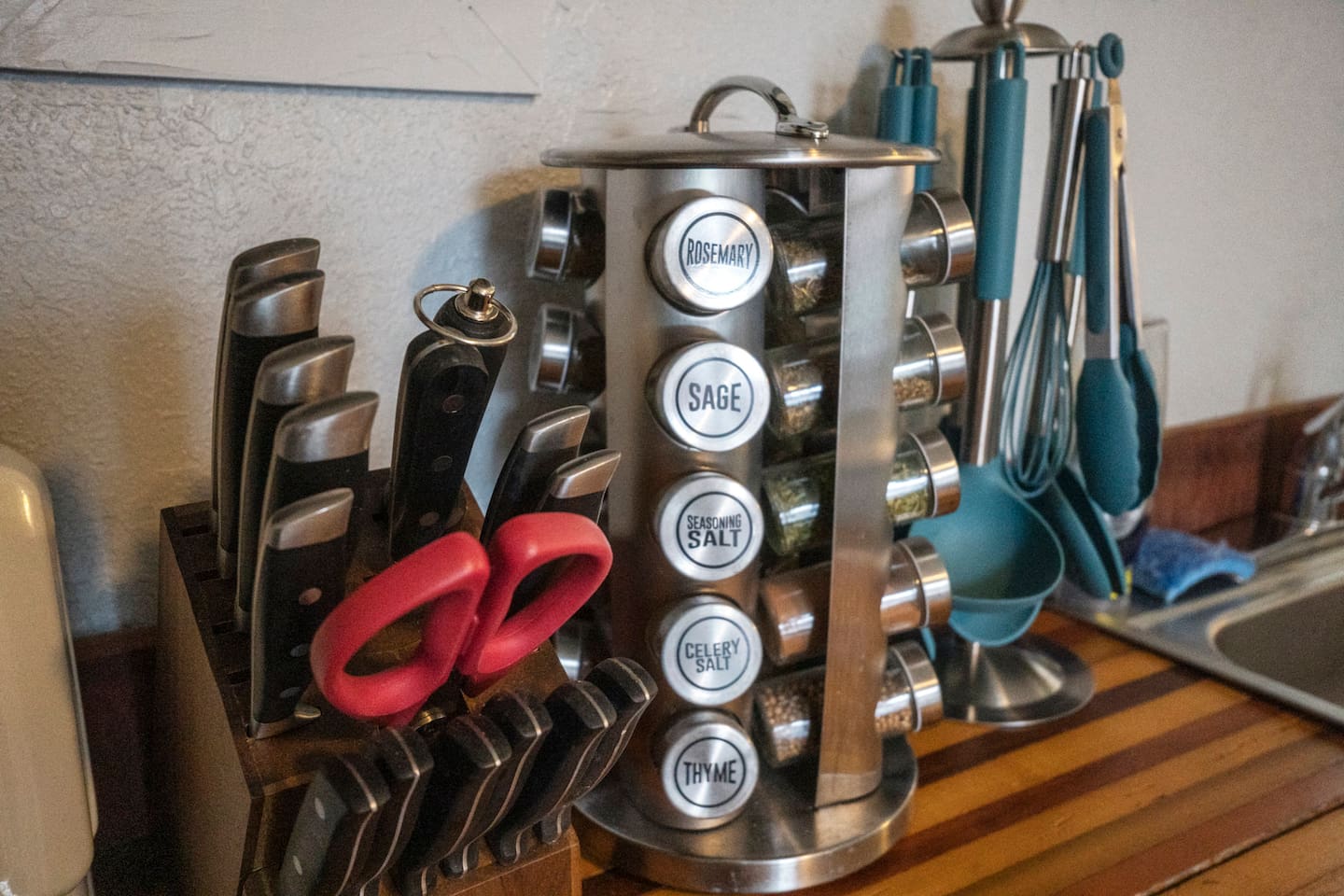 Well-organized kitchen countertop featuring a selection of spices, a knife block, and essential kitchen utensils for your cooking convenience.
