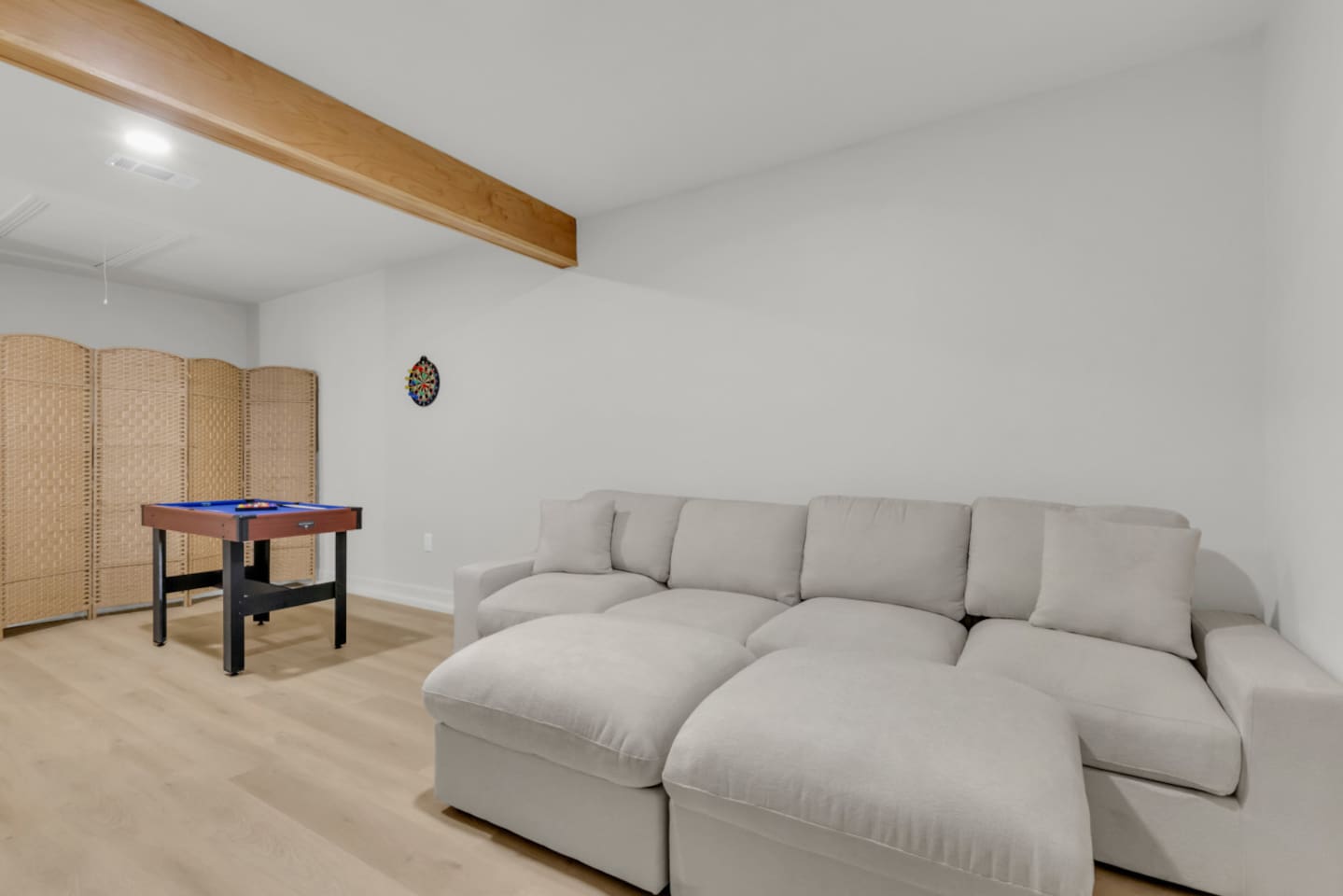 Spacious cinema/game room with a plush sectional, perfect for relaxing between rounds at the pool table or darts. A cozy extension of your private indoor entertainment space.