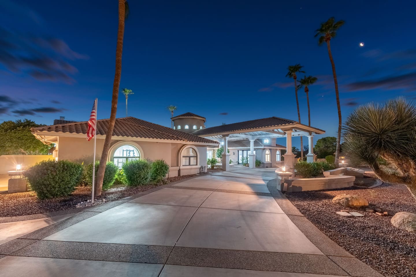 A sweeping driveway framed by palm trees and ambient lighting welcomes you to this private, resort-style escape.

