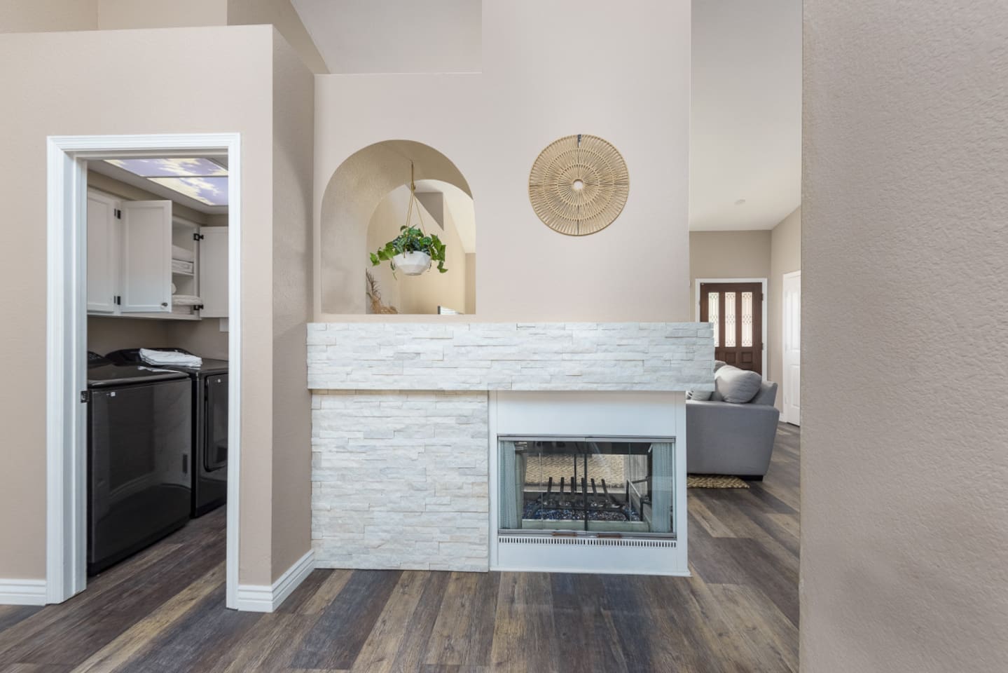Fireplace wall near the laundry room, adding a central feature between the home’s main spaces.