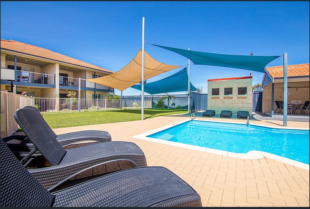 Crystal clear shared swimming pool and sun lounges
