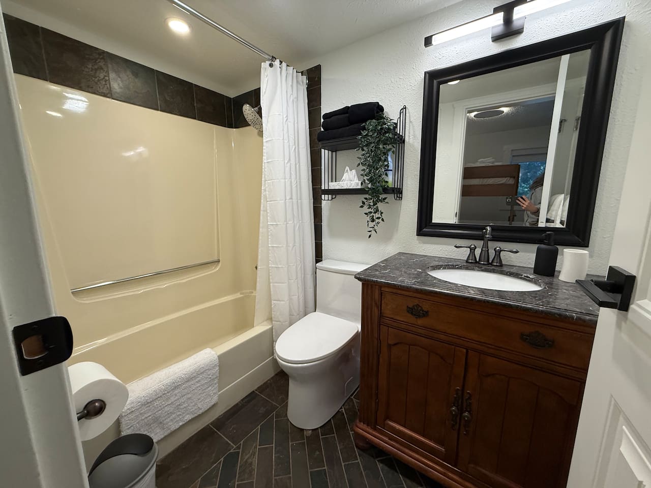 Main Floor Bathroom Details: A clean and functional space with a new comfort-height toilet and convenient shelving to keep toiletries organized.