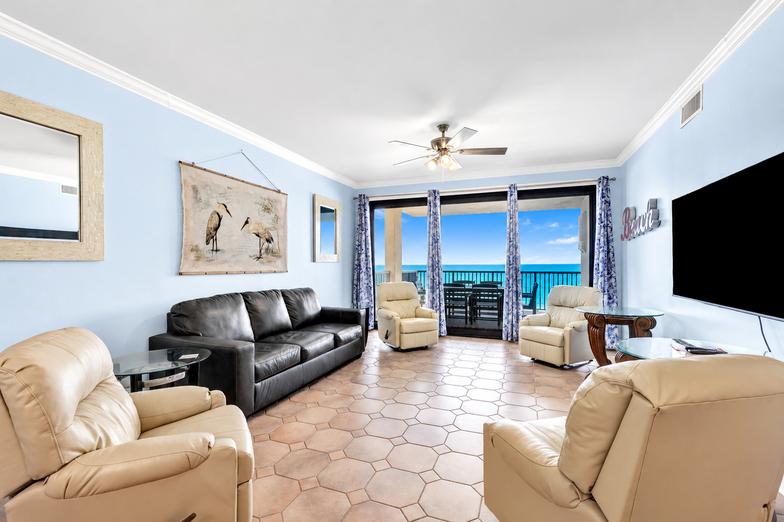 Living room with leather sleeper sofa, 4 rocking recliners, 65" wall mounted TV, breathtaking view and balcony access