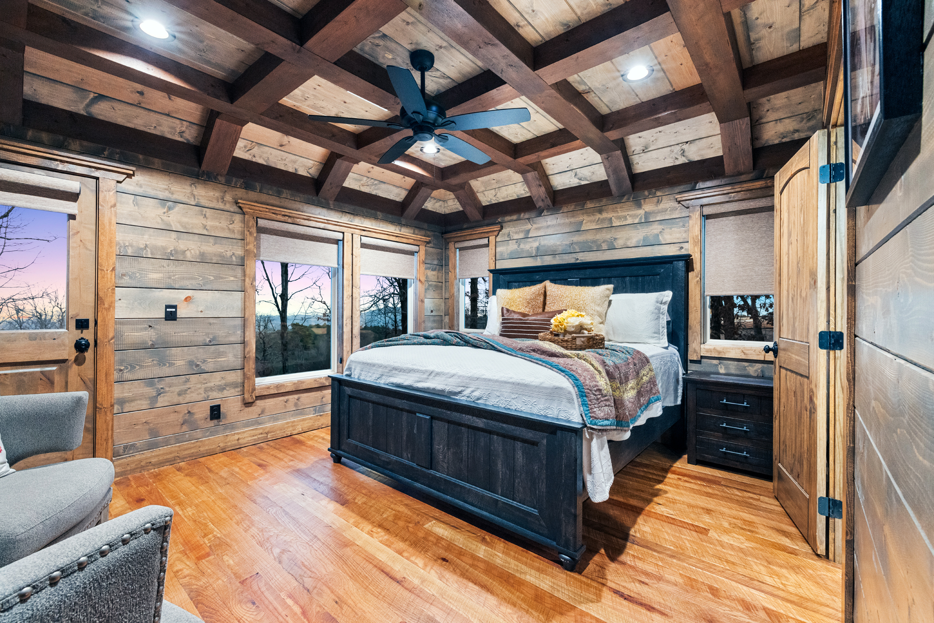 Luxurious master bedroom with exposed beam ceilings and warm rustic elegance