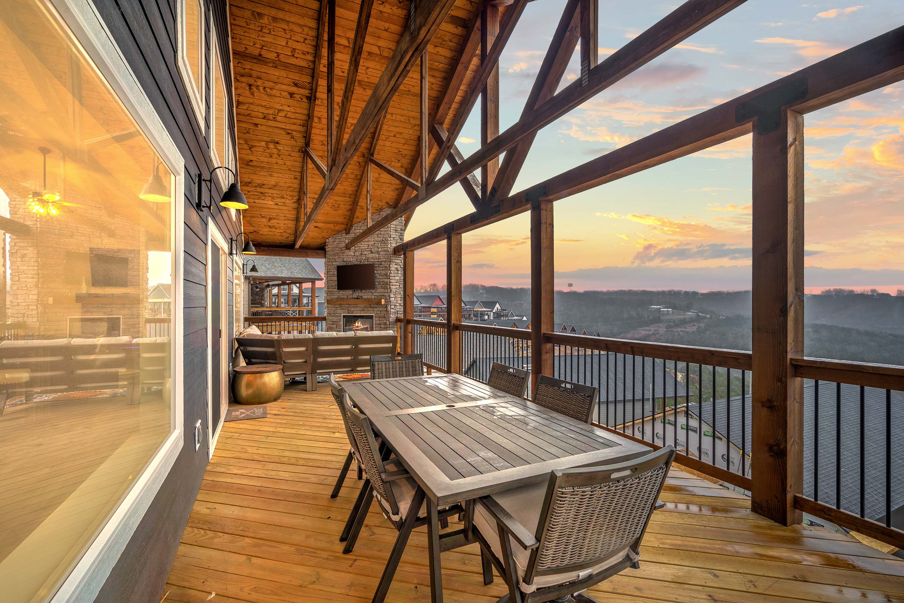 Upper deck with outdoor eating area for six people and an outdoor sitting area by the fireplace and TV.