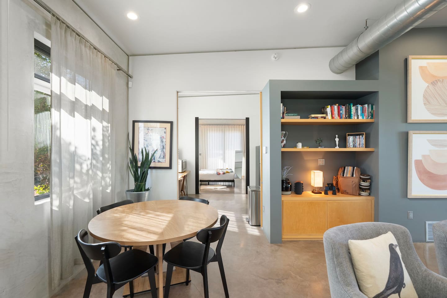 Cozy dining nook with built-in shelving and a seamless flow into the bedroom and living areas.