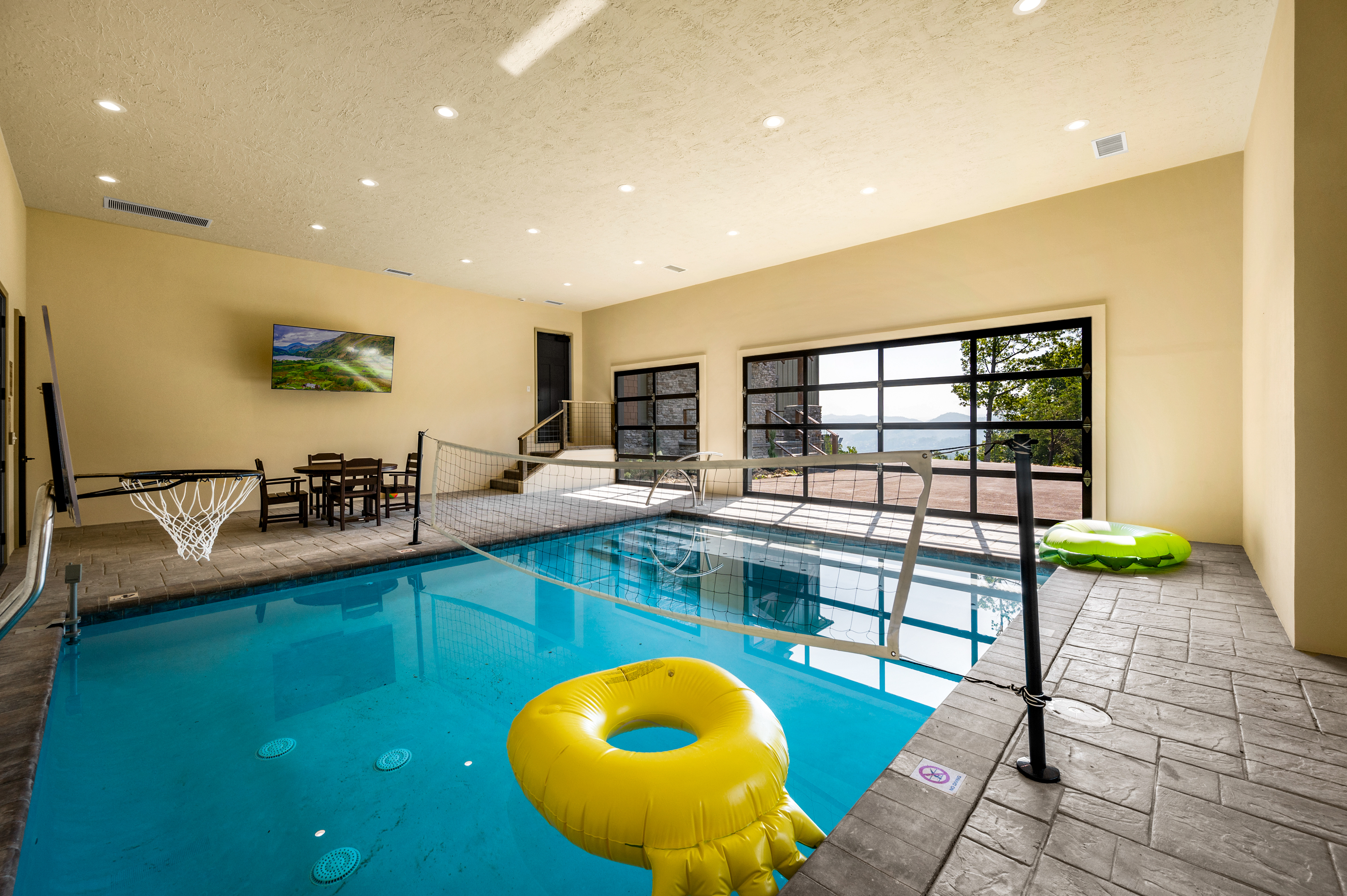 16 x 20 ft heated salt water pool with basketball, volleyball, seating and smart TV.