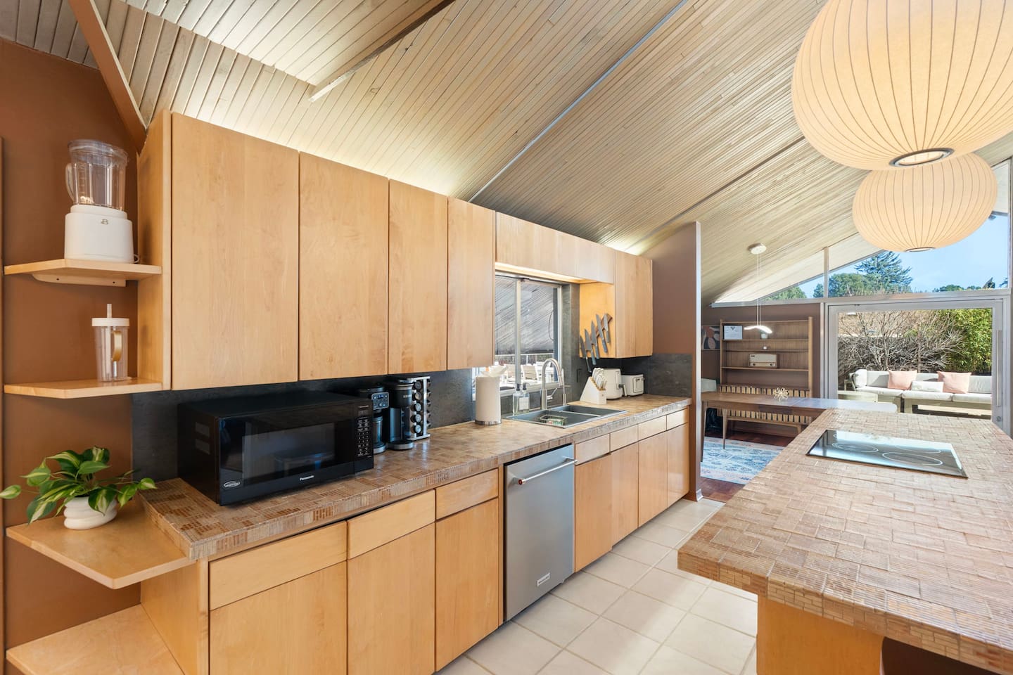 Bright, fully stocked kitchen with warm wood finishes and open views to the living area.