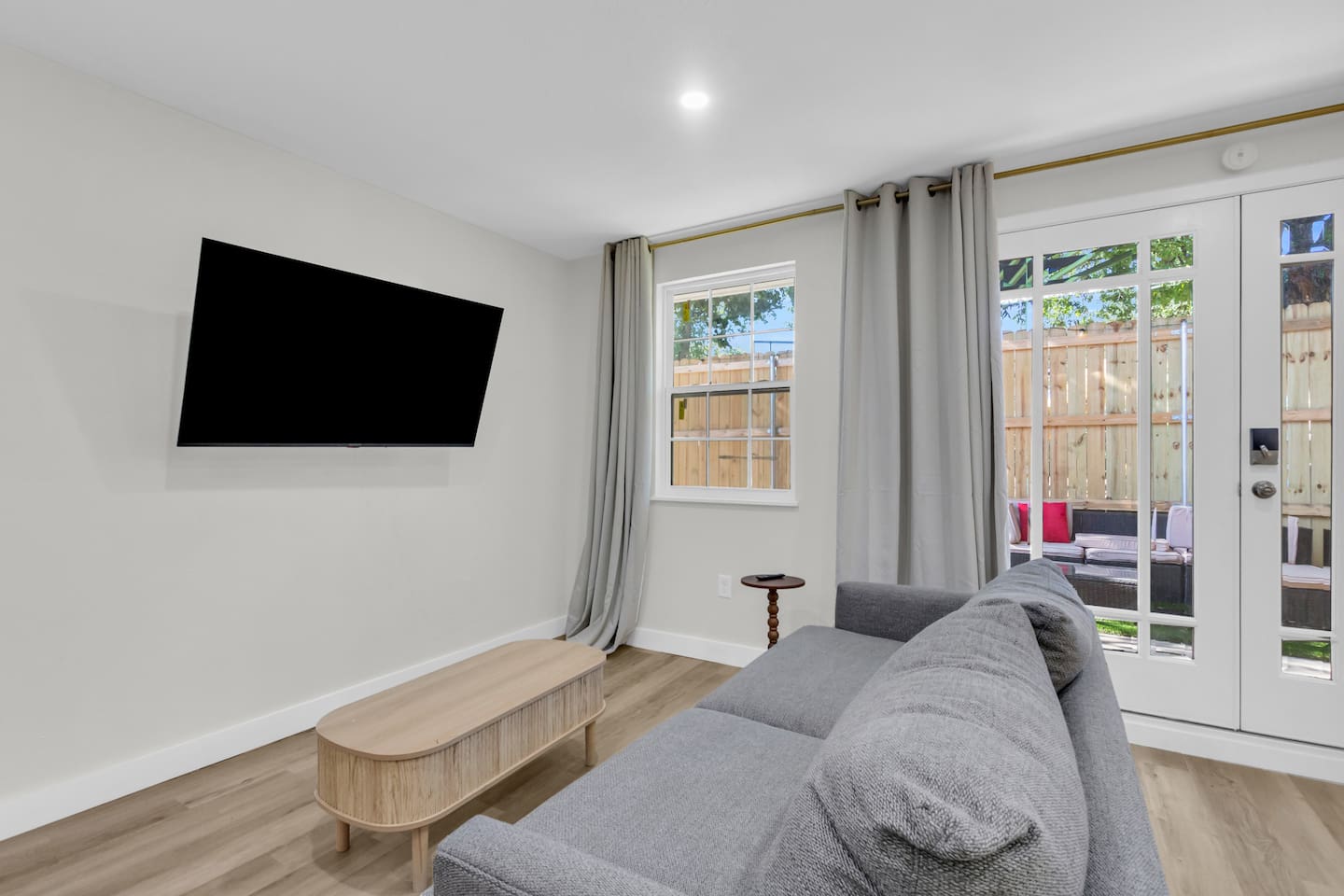 Relax in the cozy living area with Smart TV, comfortable couch, and coffee table—all overlooking the peaceful patio view.