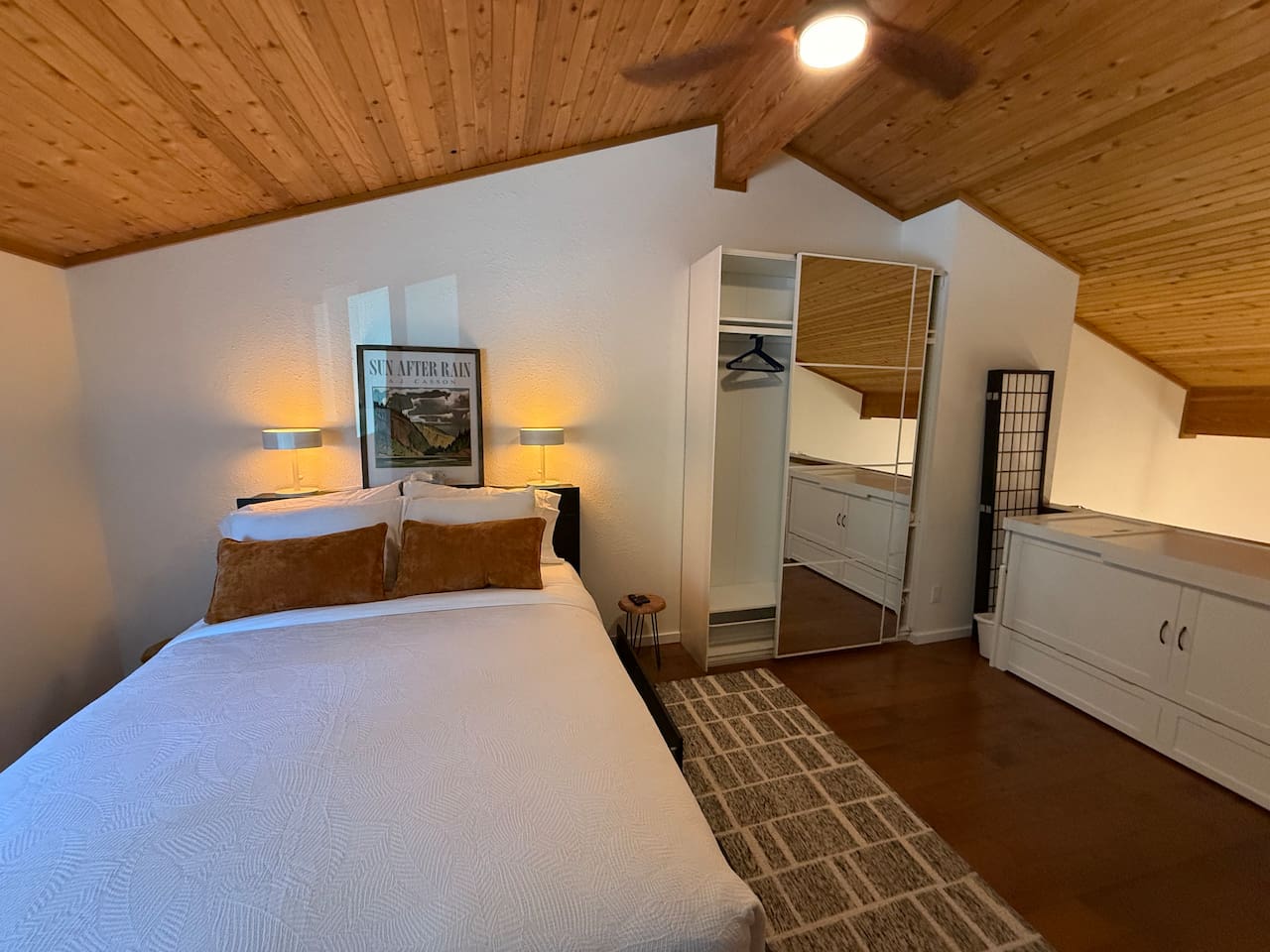 Upper Loft Bedroom: A bright, private bedroom suite with a cozy queen bed, excellent natural light, and convenient access to an en-suite bathroom and closet storage.