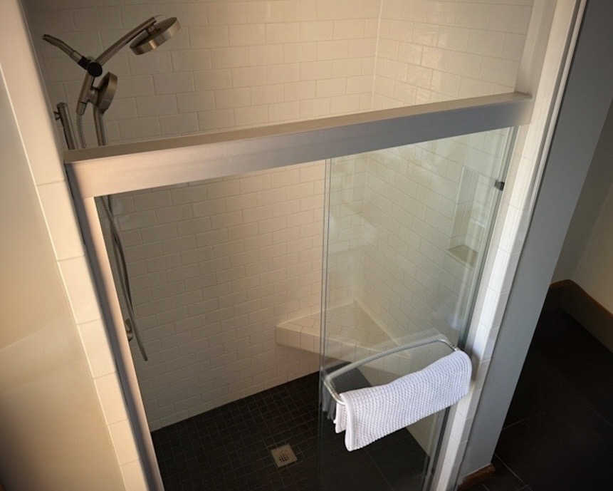 The enormous shower has a built-in tiled bench.