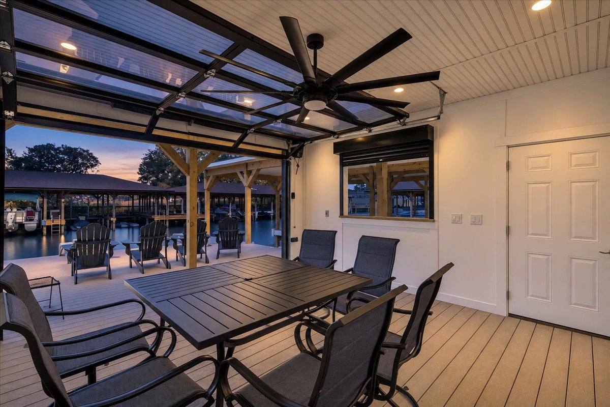 Finished boathouse entertaining space with glass garage door opening directly to the waterfront deck.