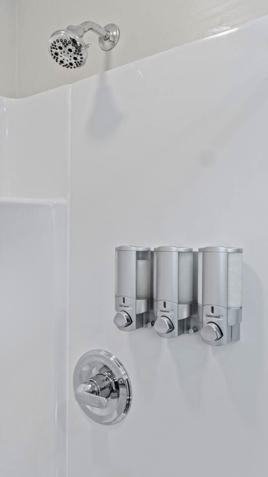 Bathroom shower equipped with essential toiletries, ensuring a comfortable and refreshing experience.