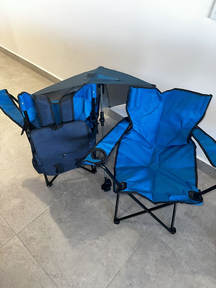 Discover backpack beach chairs, a convenient umbrella, and a backpack cooler in the laundry room, neatly stored above the washer and dryer.