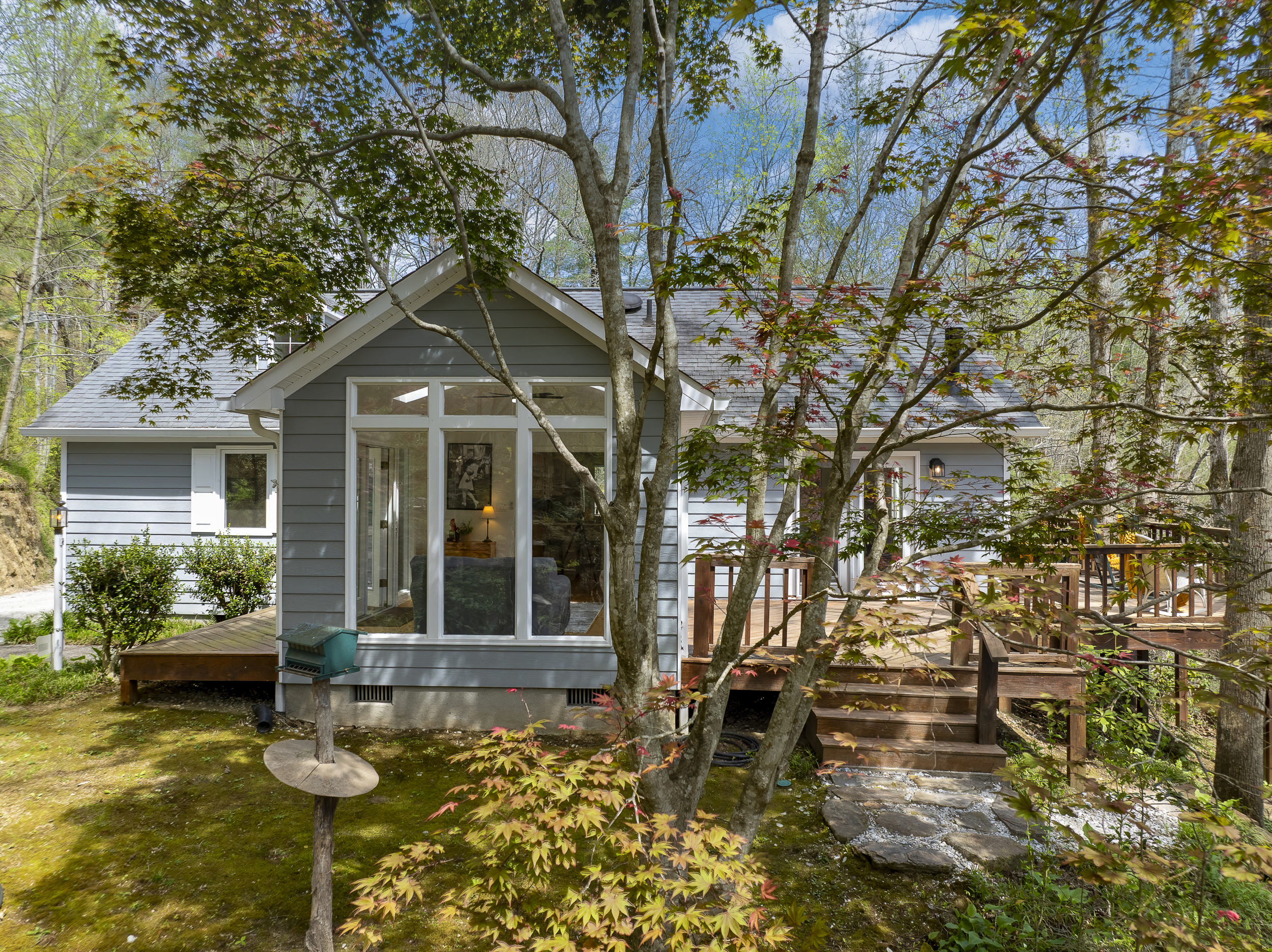 Exterior Retreat: Embrace nature on the deck surrounded by lush greenery and vibrant views!