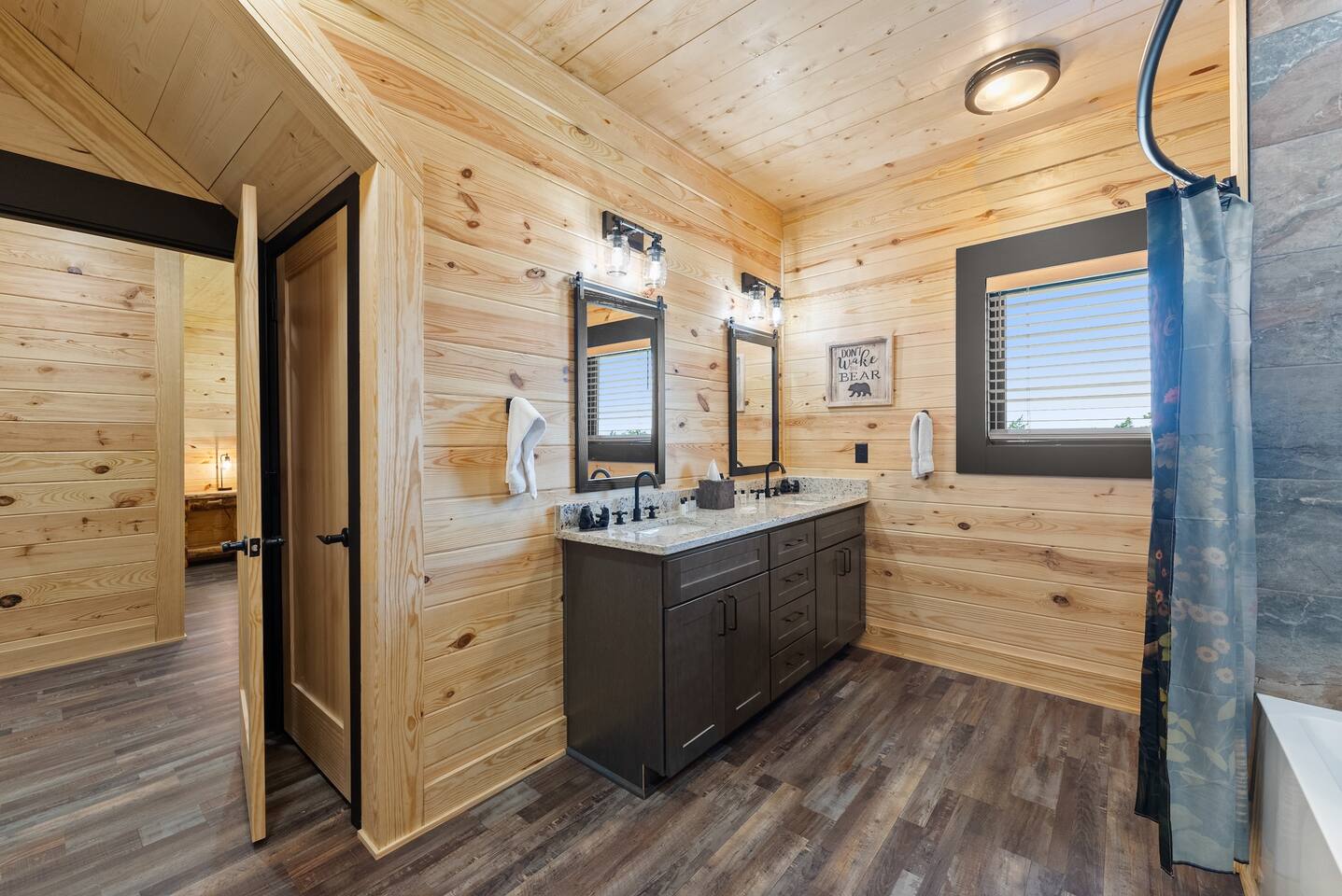 Stylish tub-shower combo with tile surround and pebble accents offers a relaxing place to unwind after a day in the mountains.