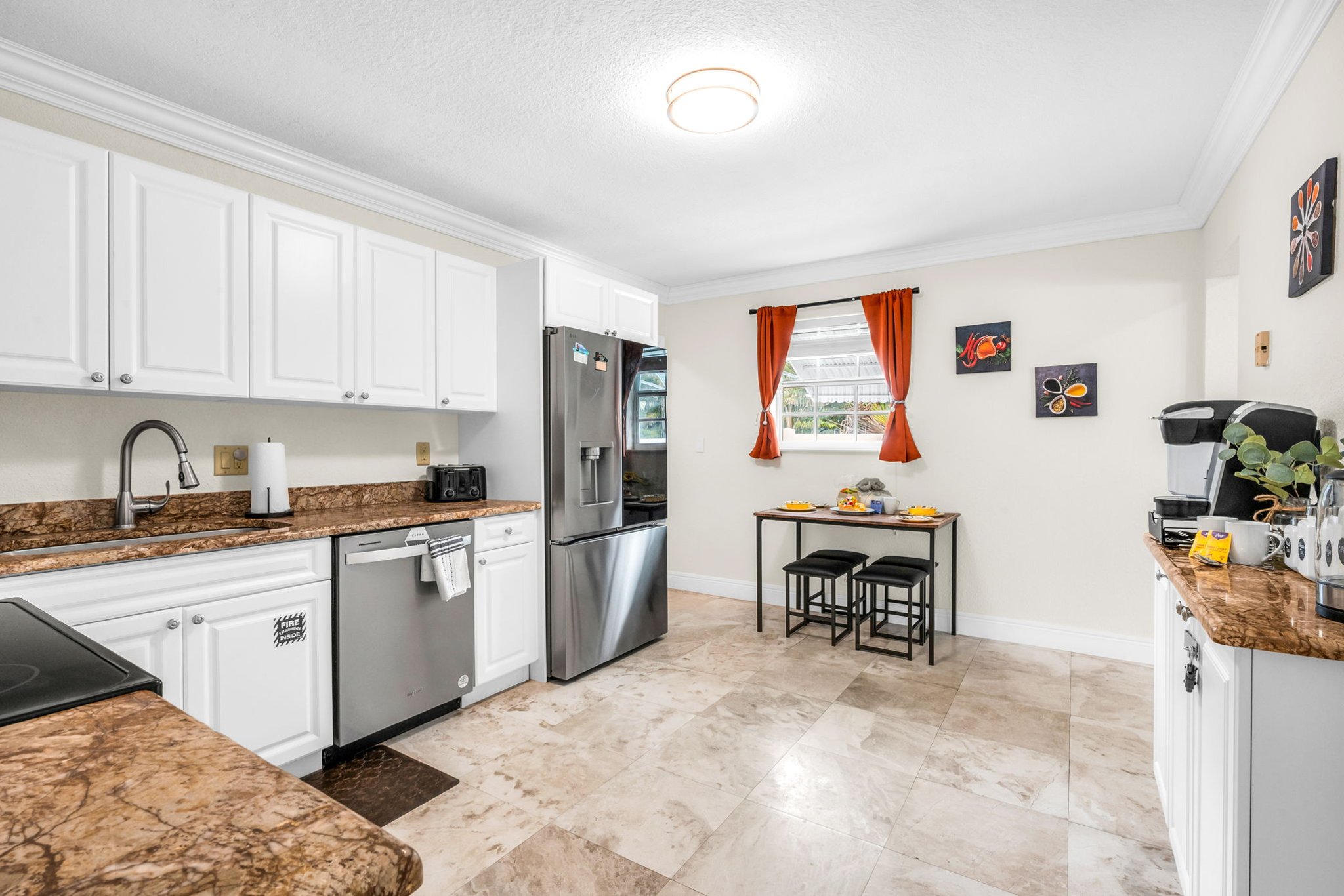 Bright, spacious kitchen featuring full-size stainless appliances, a dedicated coffee bar, and a bonus dining area with seating for four—perfect for families and groups.