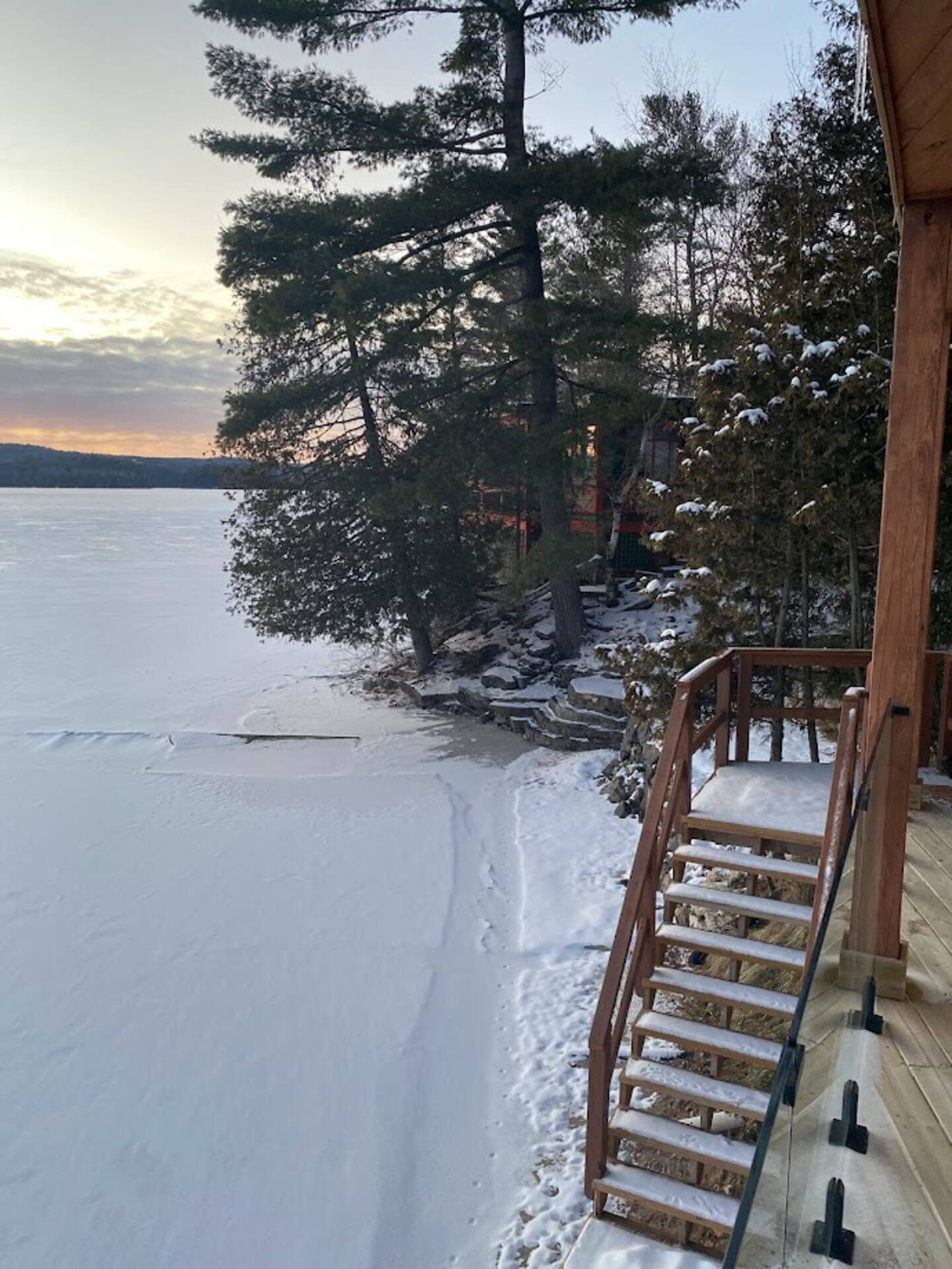 View across Lac McGregor to the west off hot tub deck area showing stairs leading to edge of lake and beach area