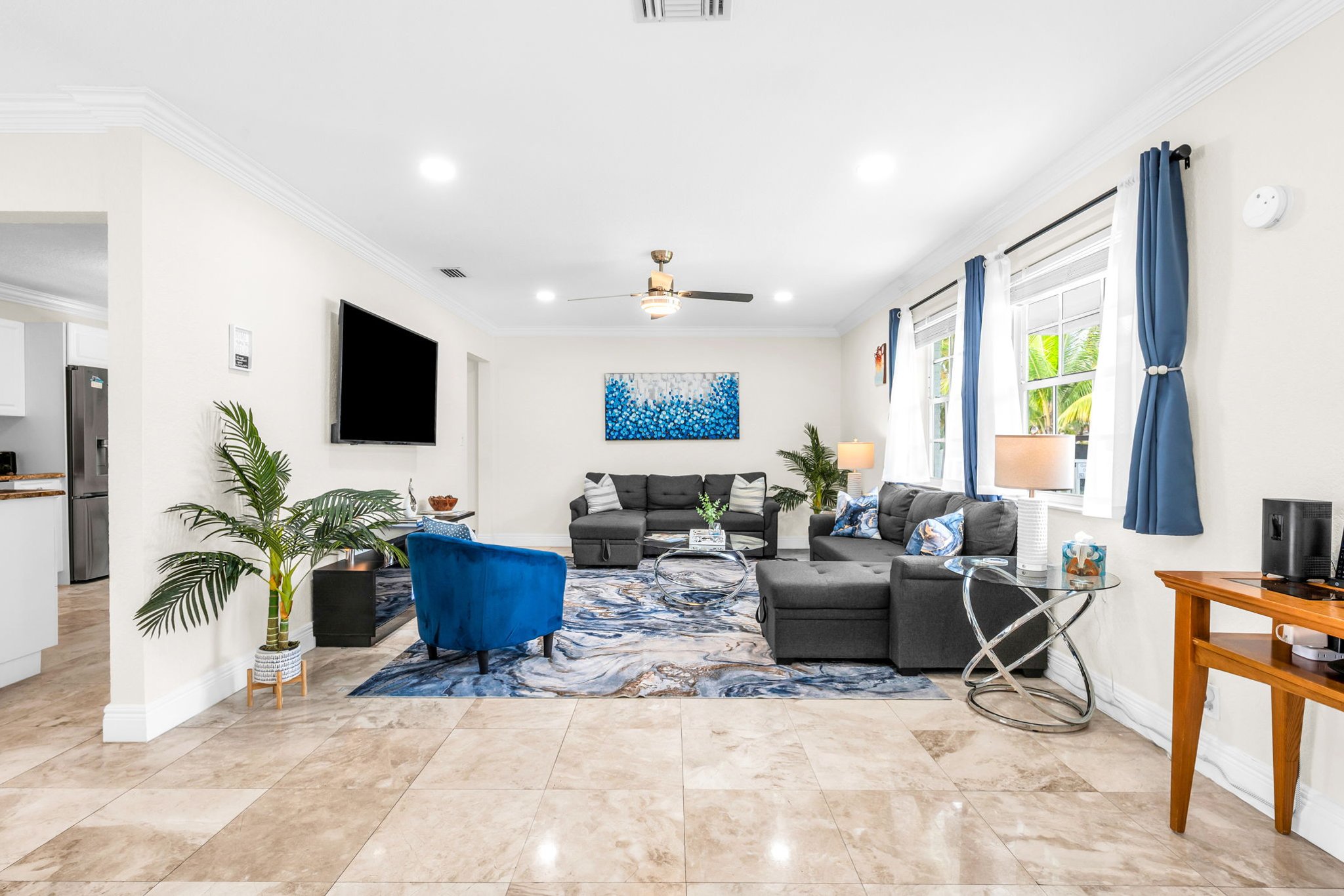 Large family-friendly living room with two queen pull-out sofas, flat-screen smart TV, and stylish coastal décor—great for groups needing extra sleeping options.