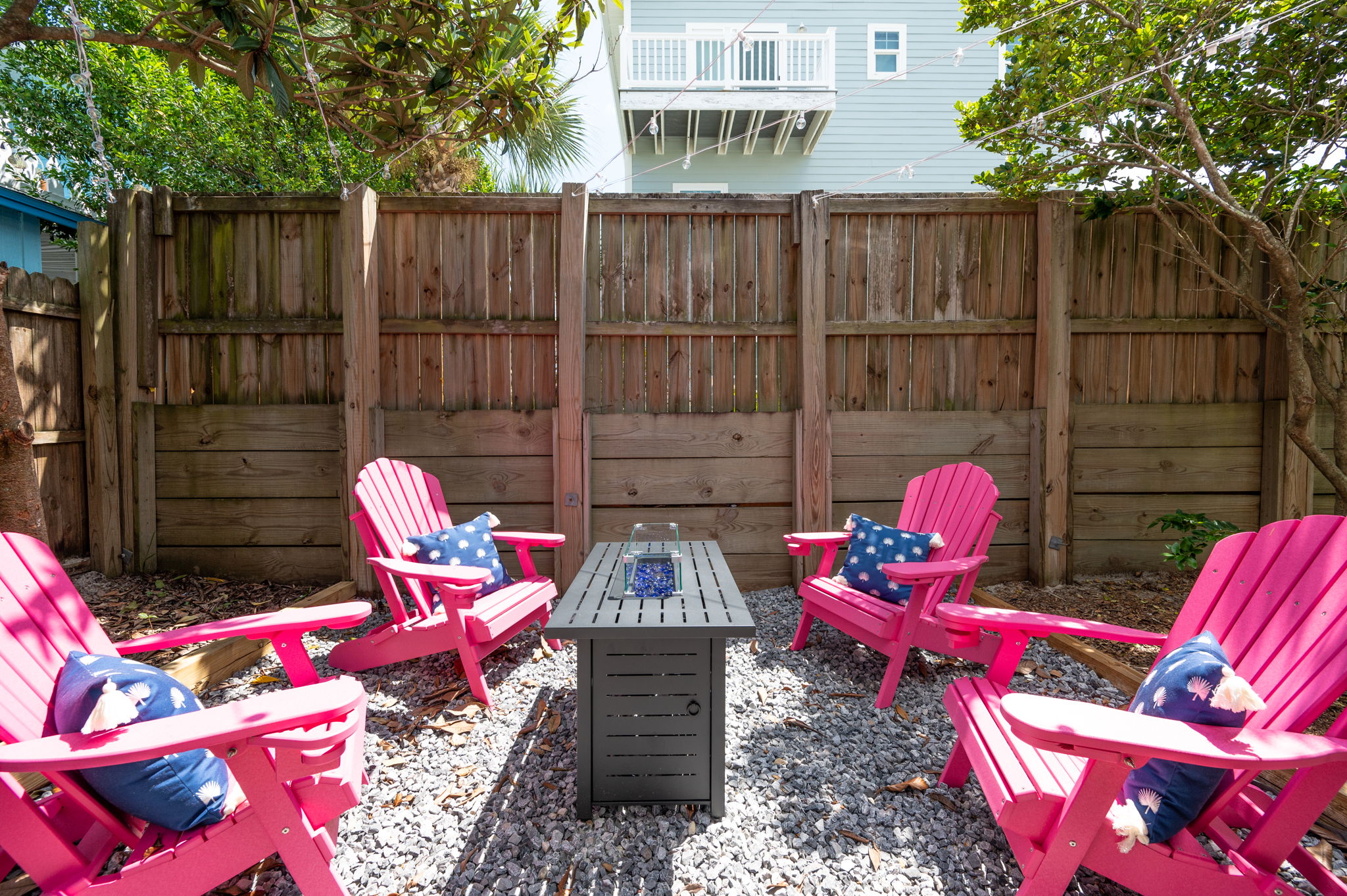 Discover your serene retreat in our charming backyard. Pink chairs, a cozy fireplace, and twinkling string lights create an inviting space for day and evening hangouts. 🔥✨ #BackyardBliss #CozyVibes