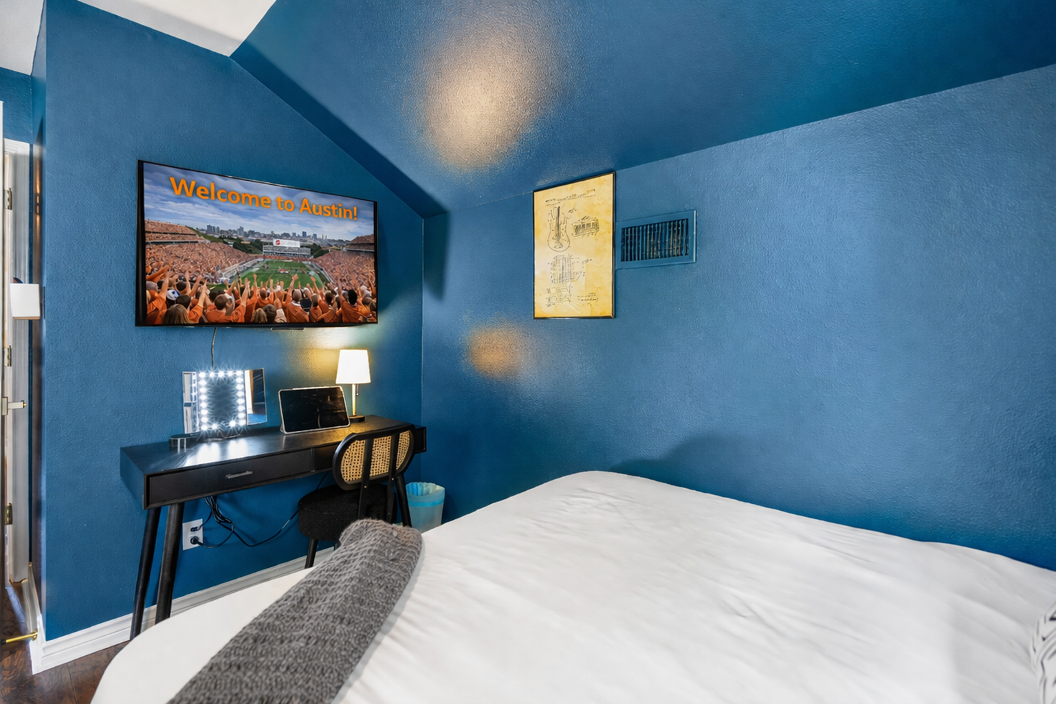 Comfortable corner bedroom with 2 Queen size beds, a wall-mounted TV and dedicated workspace. Perfect for streaming games, remote work, or unwinding after exploring Austin.
