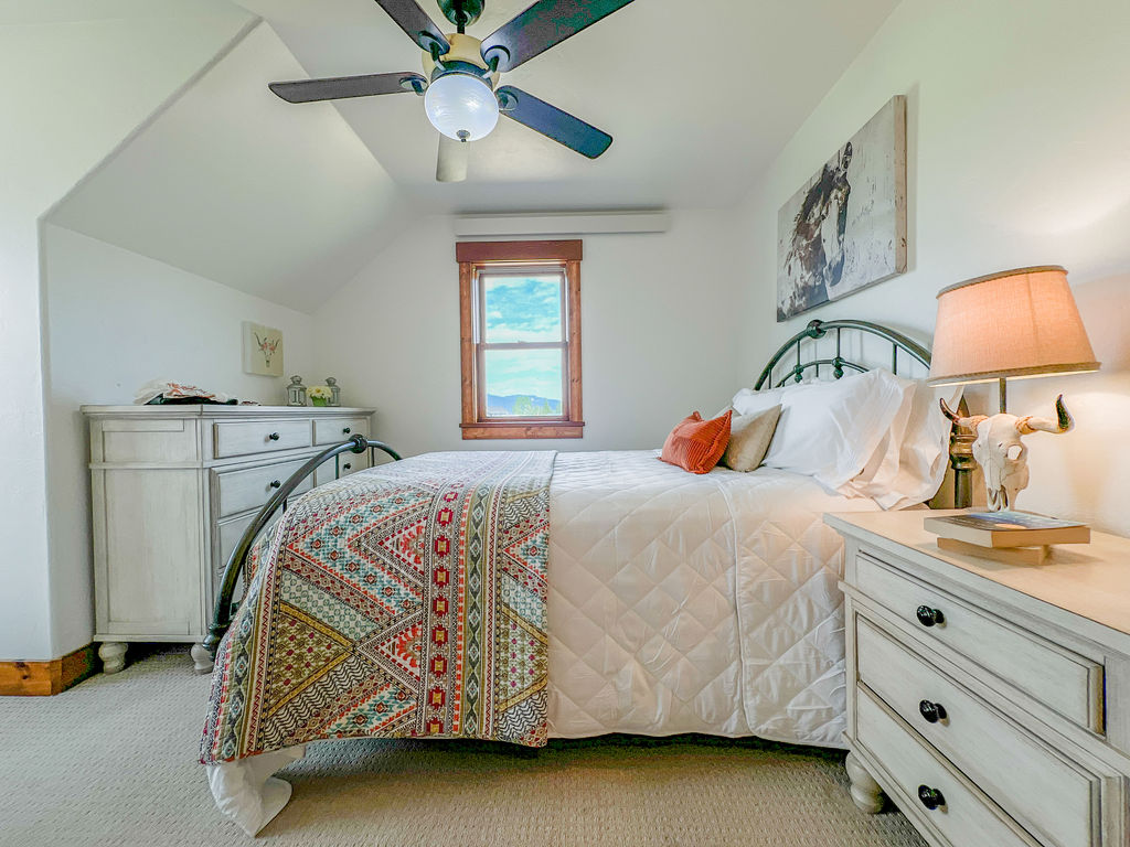 Enjoy this quiet, cozy room featuring a queen bed, large dresser, hanging closet, and views!