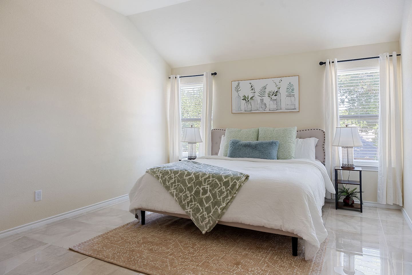 Enter a calm bedroom with a comfortable bed, chic bedside lights, and subtle wall art of botanicals.