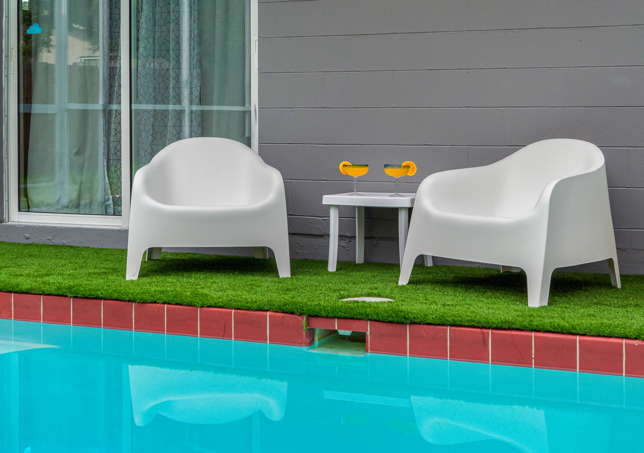With padded loungers, a mounted outdoor TV, and thoughtful design, this backyard delivers a resort-style experience in full privacy.