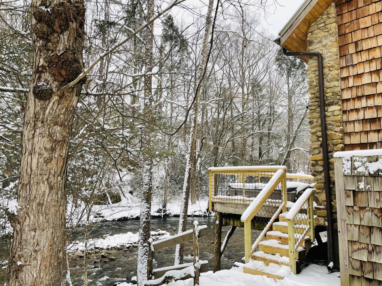 A peek of the hot tub and creek in the snow
