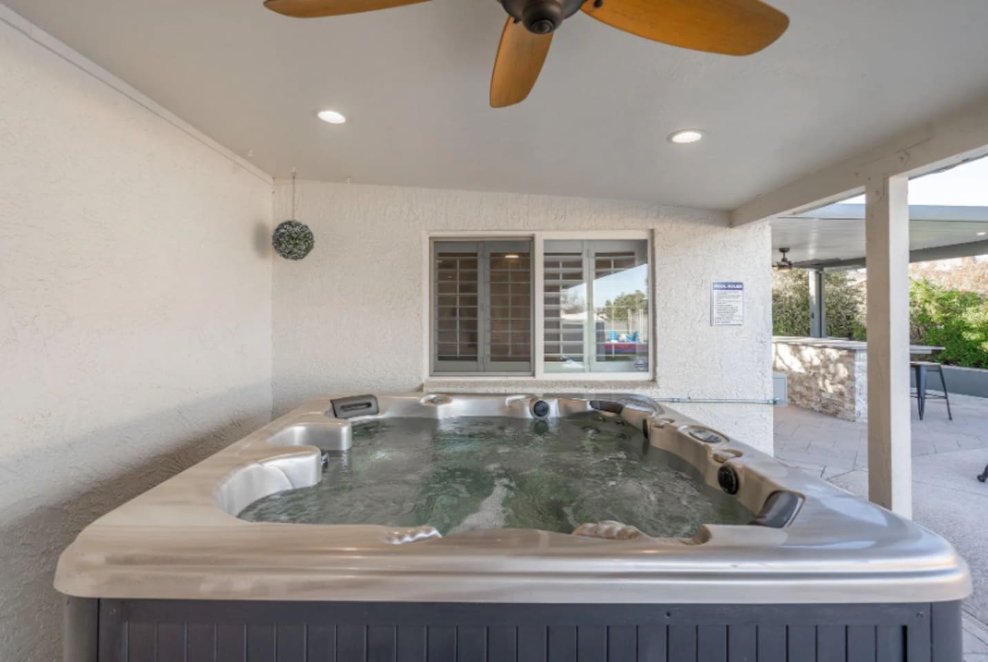 Tucked under a covered patio, this hot tub stays comfortable rain or shine, with ceiling fans keeping the air moving on warm days.
