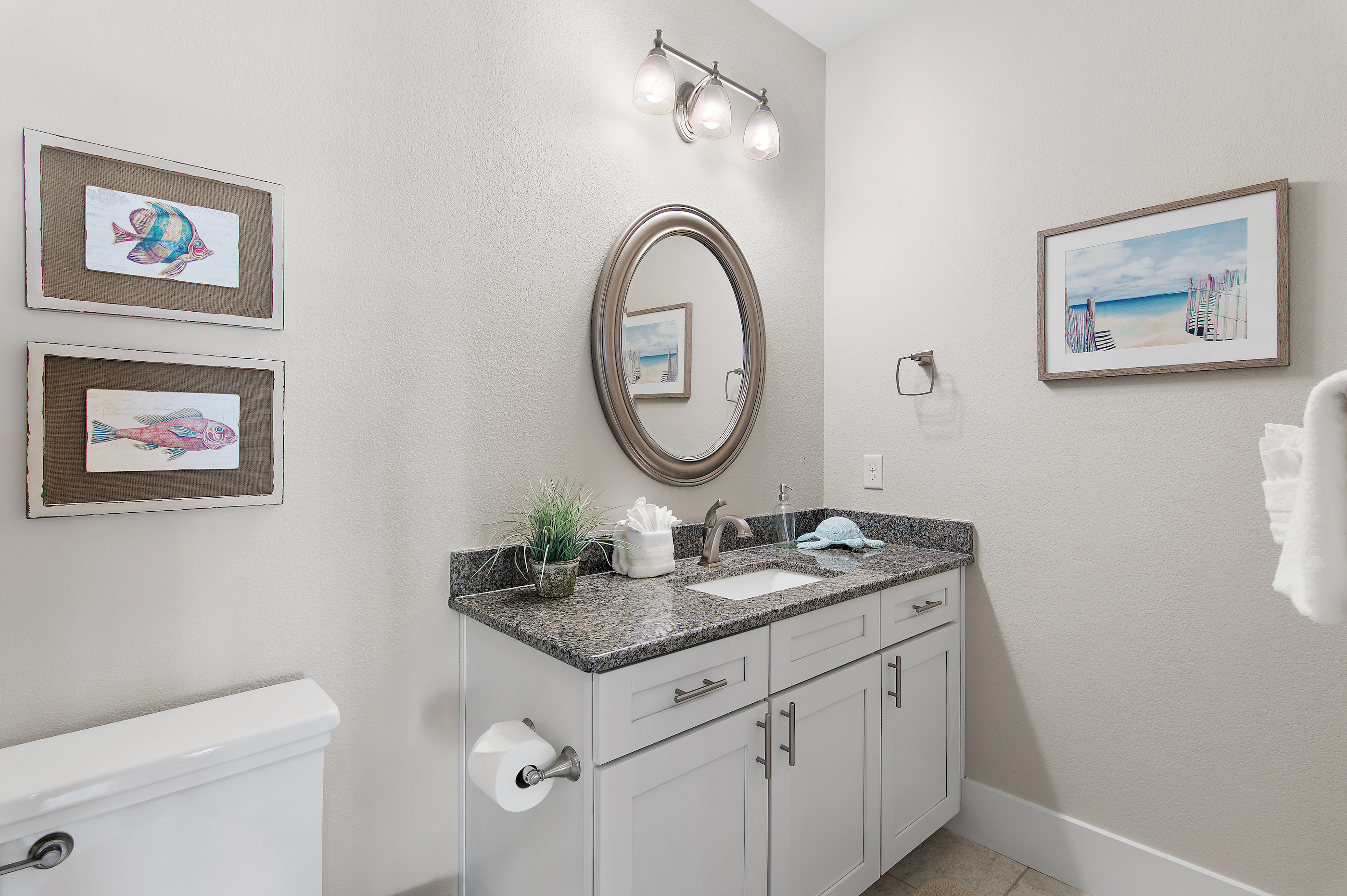 Bright, spacious bathroom with generous vanity, and elegant coastal details.
