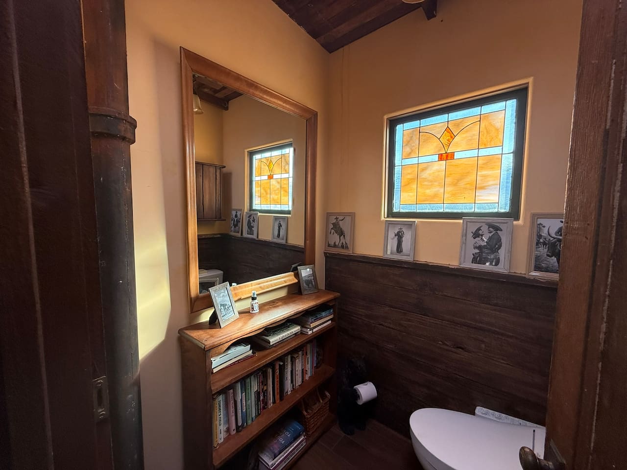 History, family and a little high-tech comfort meet in the first powder room: a Toto bidet toilet, reclaimed ranch-fence paneling stained-glass window, and lots of books to peruse should you want to linger. 