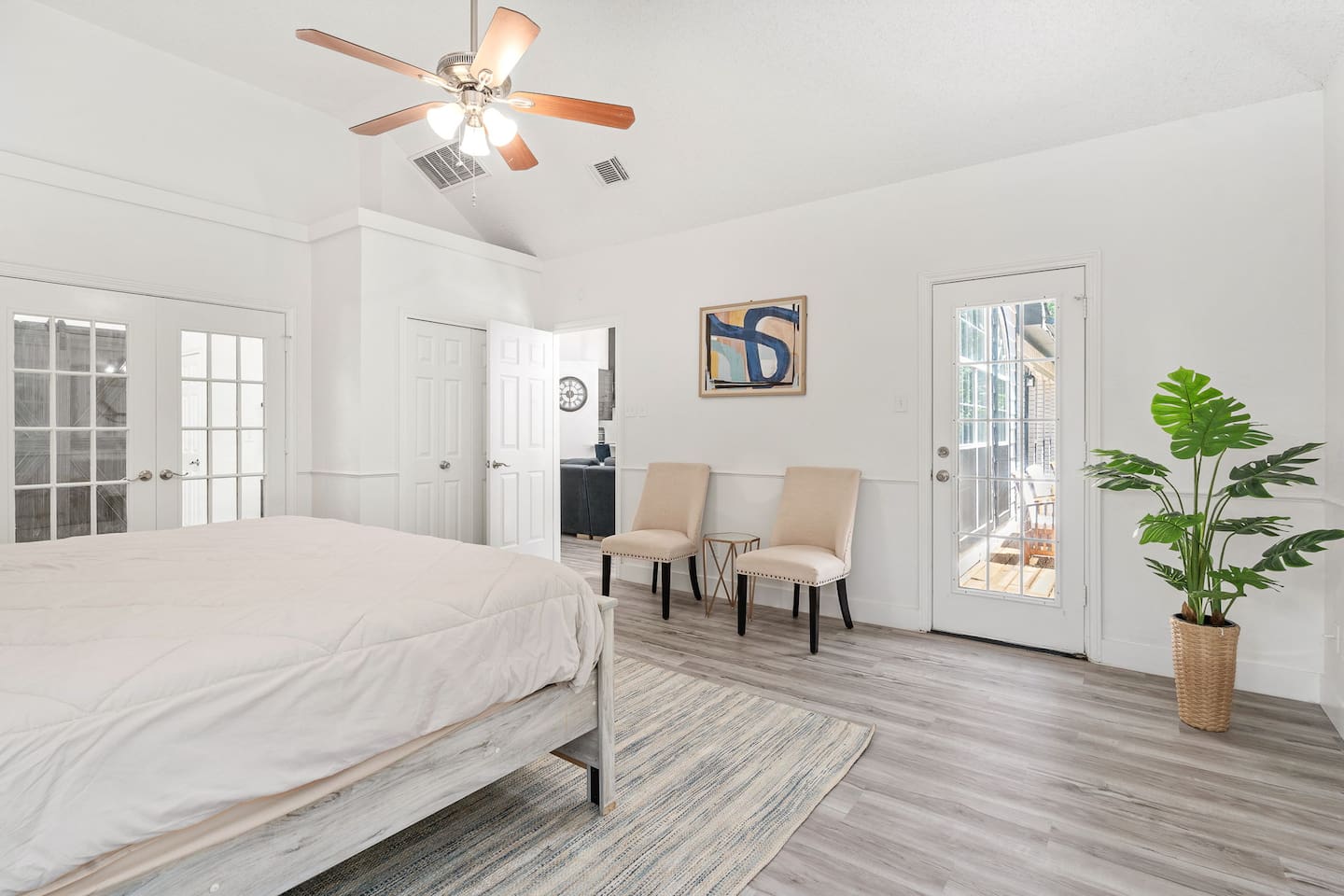 Modern master bedroom featuring cozy linens, an en suite bathroom, and direct access to the patio deck. 