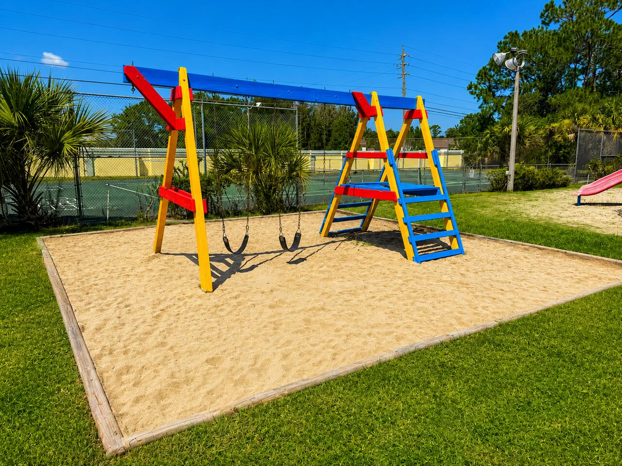 Sandy play area with swings and climbing equipment for family-friendly fun.