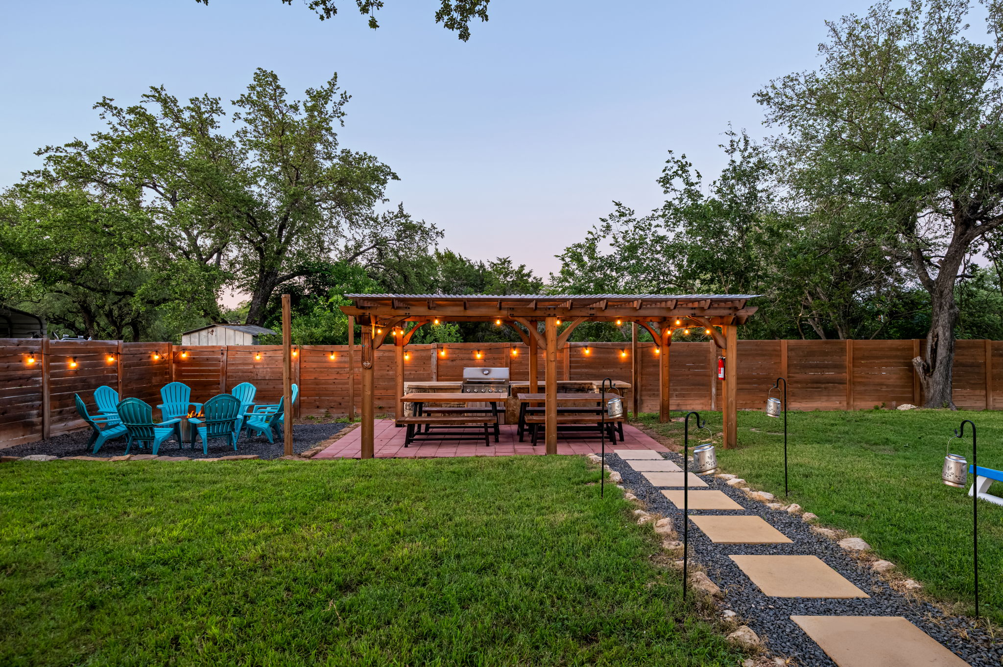 Enjoy a spacious backyard retreat with a covered BBQ area, fire pit seating, and plenty of room to relax or play. The perfect outdoor space for cookouts, evening gatherings, and memorable nights under the lights.