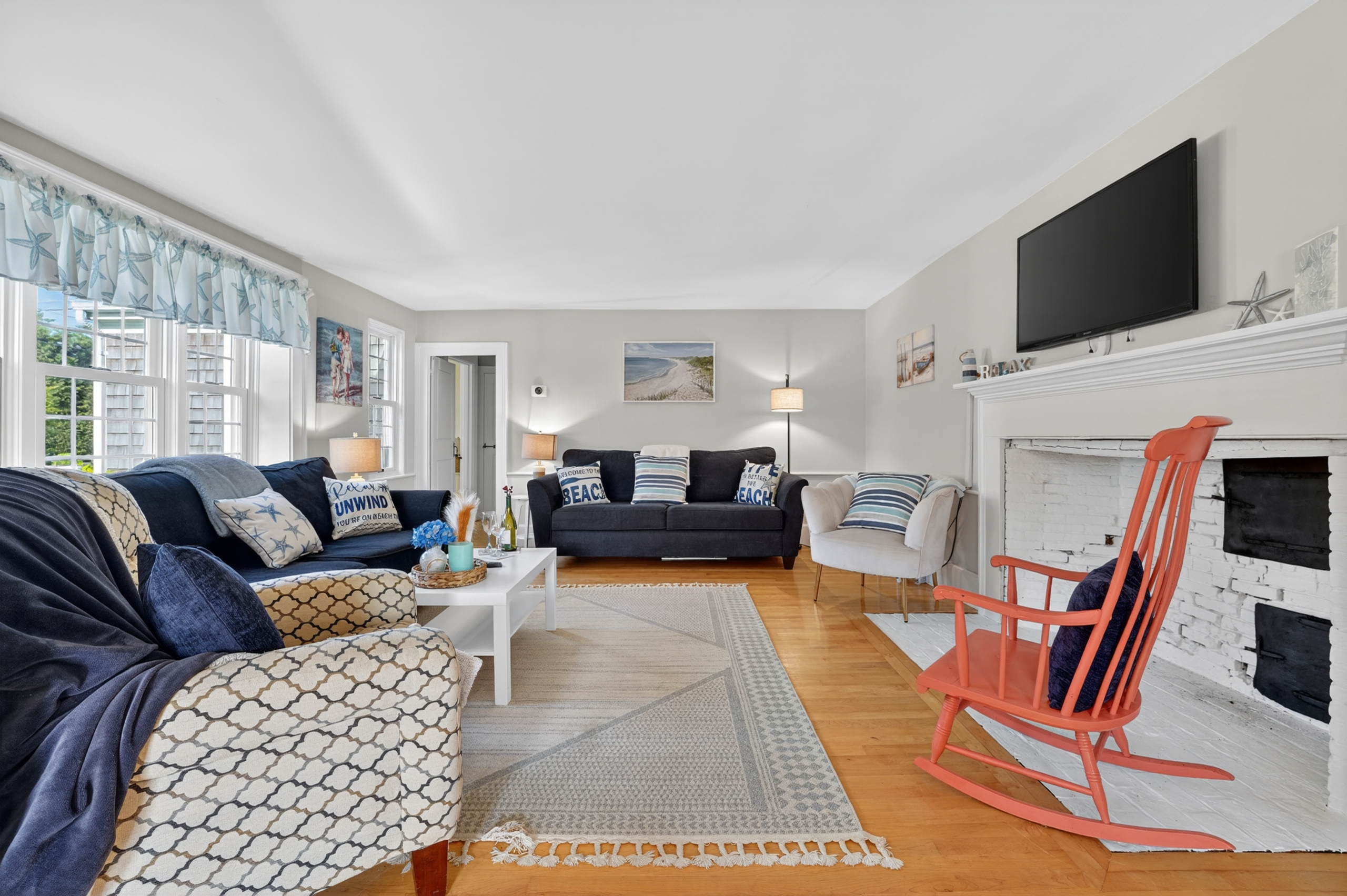 Cozy living room with a fireplace, Smart TV, and plenty of natural light.