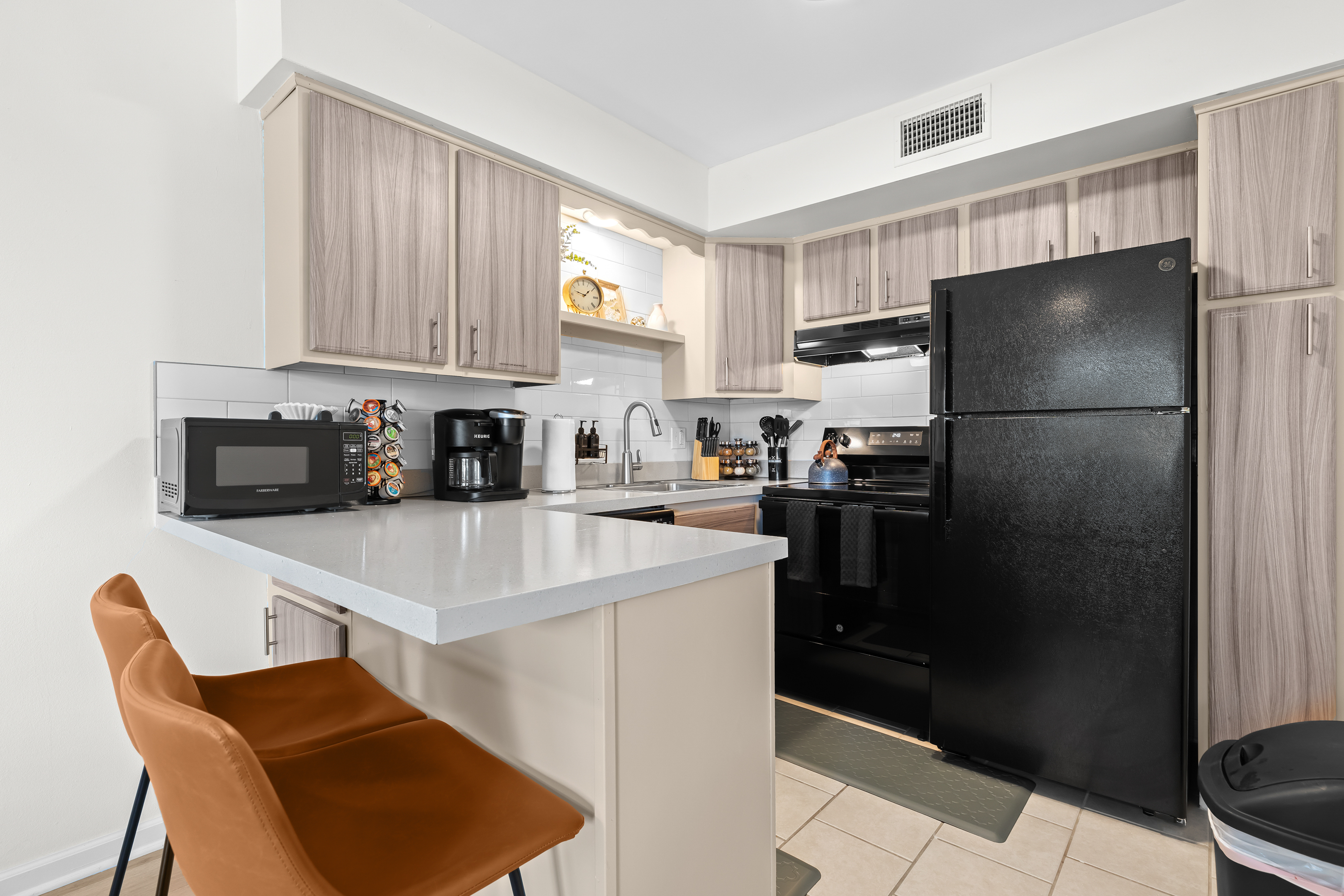 Fully equipped kitchen featuring modern appliances and bar seating.