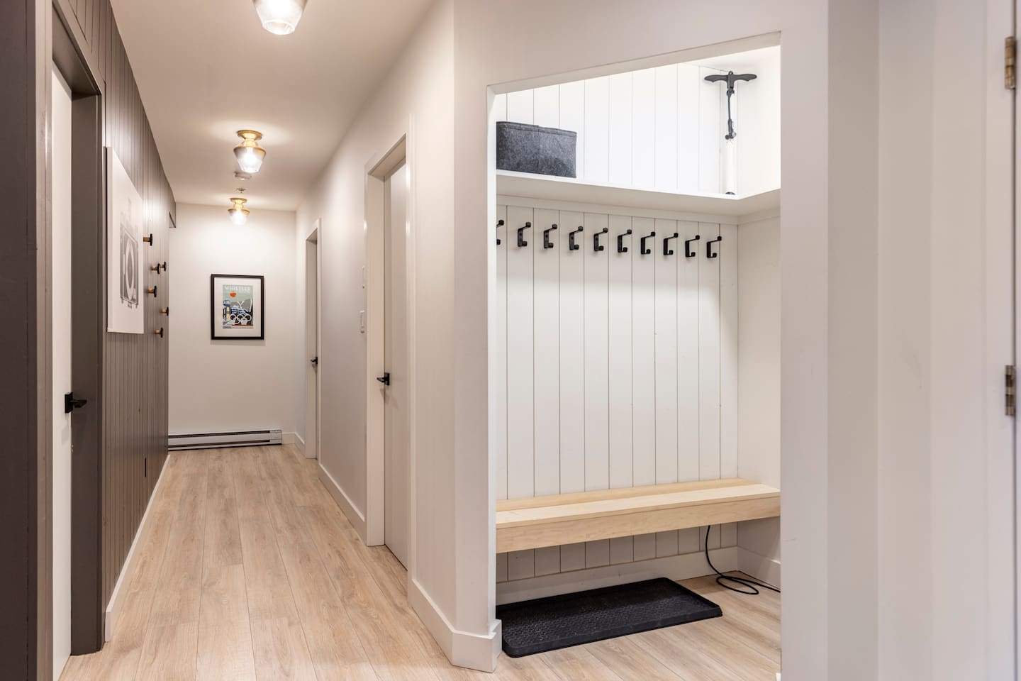 Entrance area with lots of hooks in the closet and along the hallway wall. A boot dryer is in the closet area.