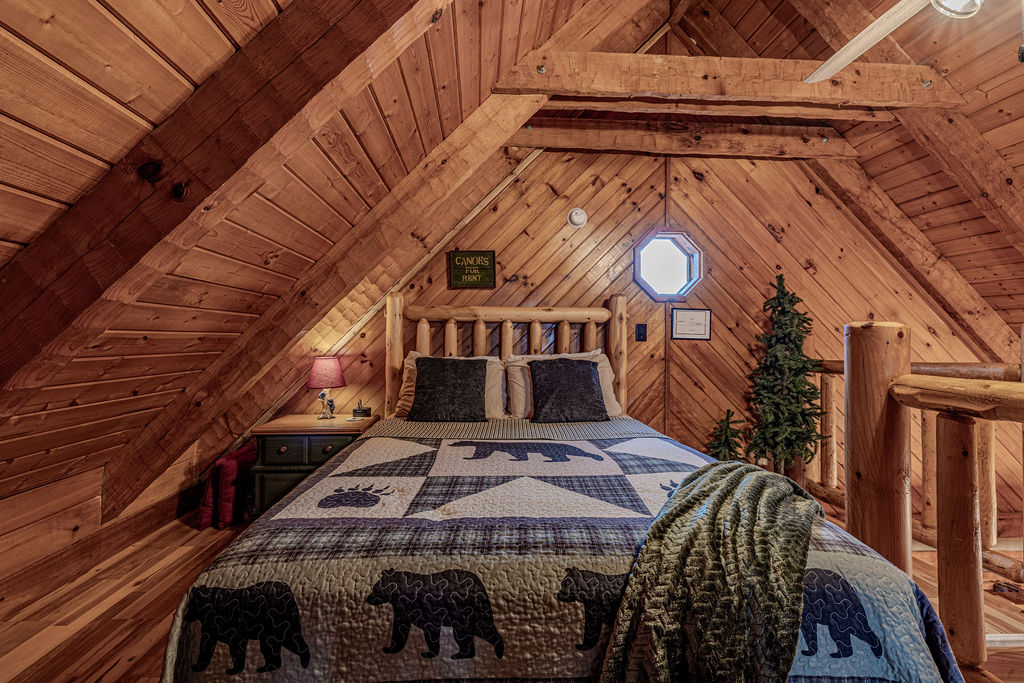 Rustic loft bedroom with wood-beam ceilings and a charming mountain feel.