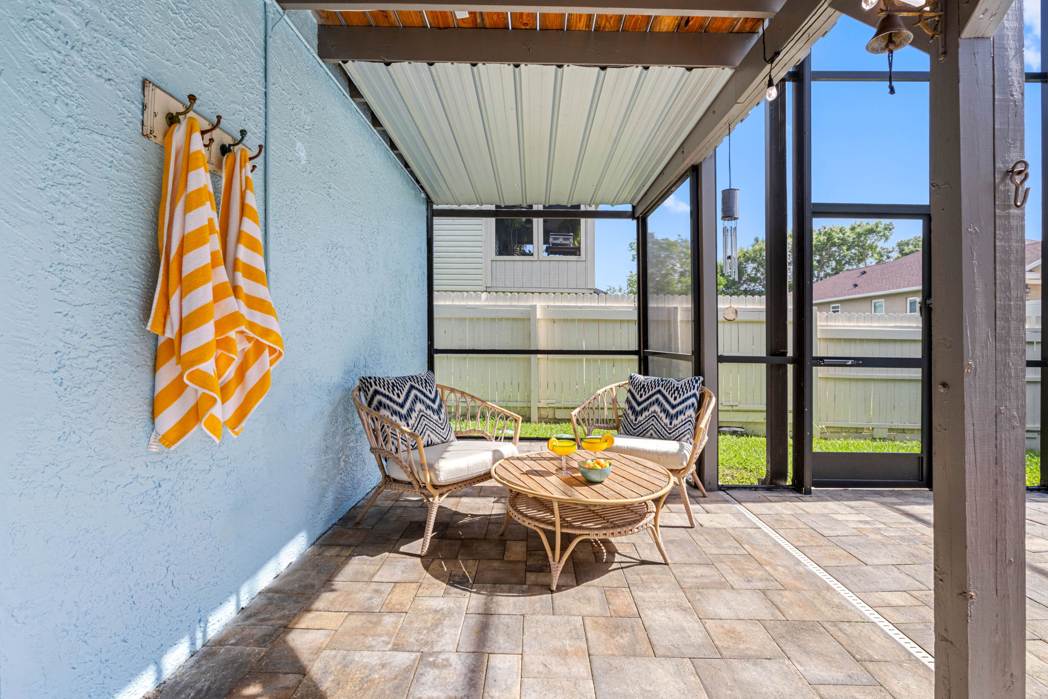 Stay cool under the covered patio, enjoy the ambiance of hanging lights, or dive into the pristine pool—all in your private, screened-in backyard sanctuary.