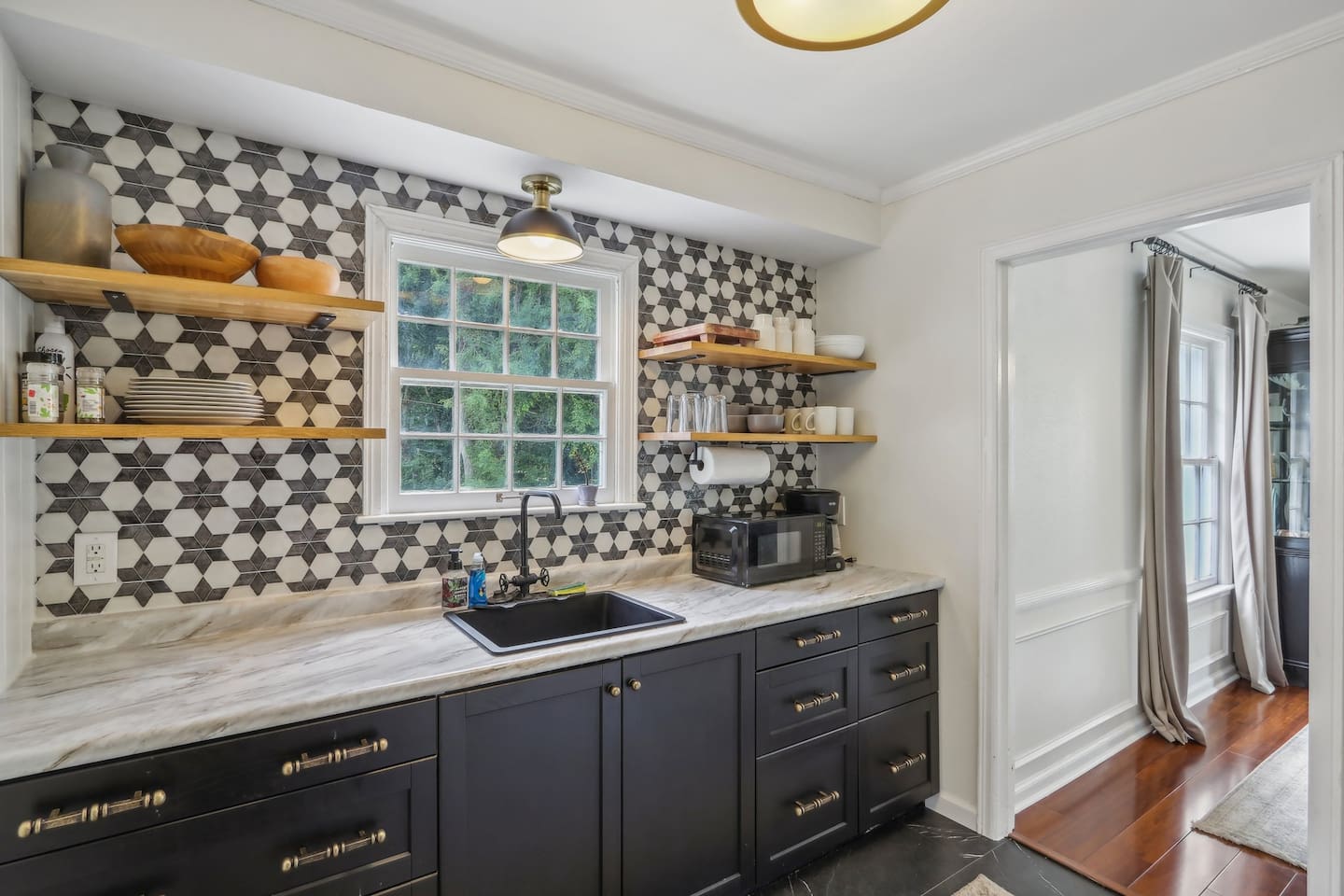 Whip up breakfast or a quick meal in this charming kitchen, where bold patterned tile and open shelving add plenty of personality.