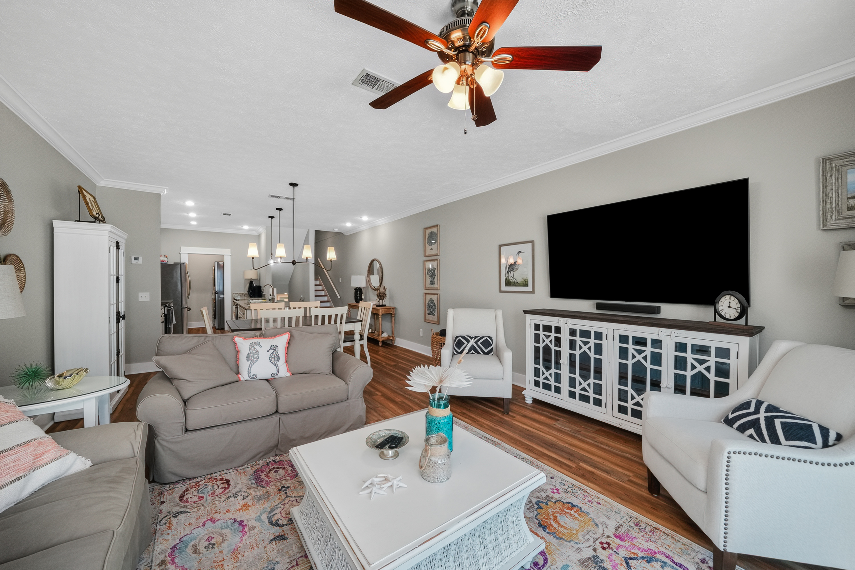 Bright, airy living space with Smart TV, ceiling fan, comfortable seating, natural light, and a welcoming atmosphere, perfect for relaxing after a day at the beach