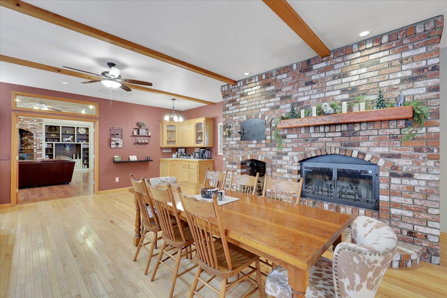 Dining area with a large table, brick fireplace, and easy access to the living room.

