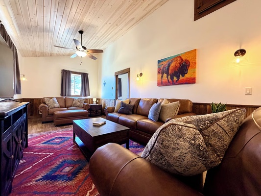 Elk Suite living area featuring leather sofas with a queen sofa sleeper and smart tv.